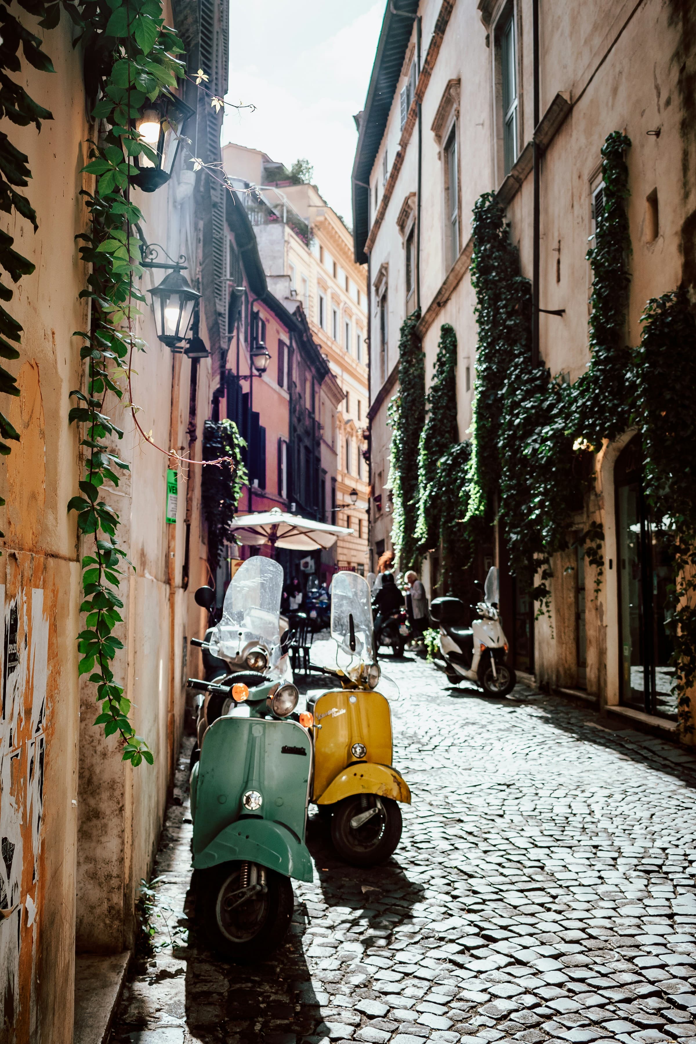 Scooters parked beside the cobbled street of Rome.