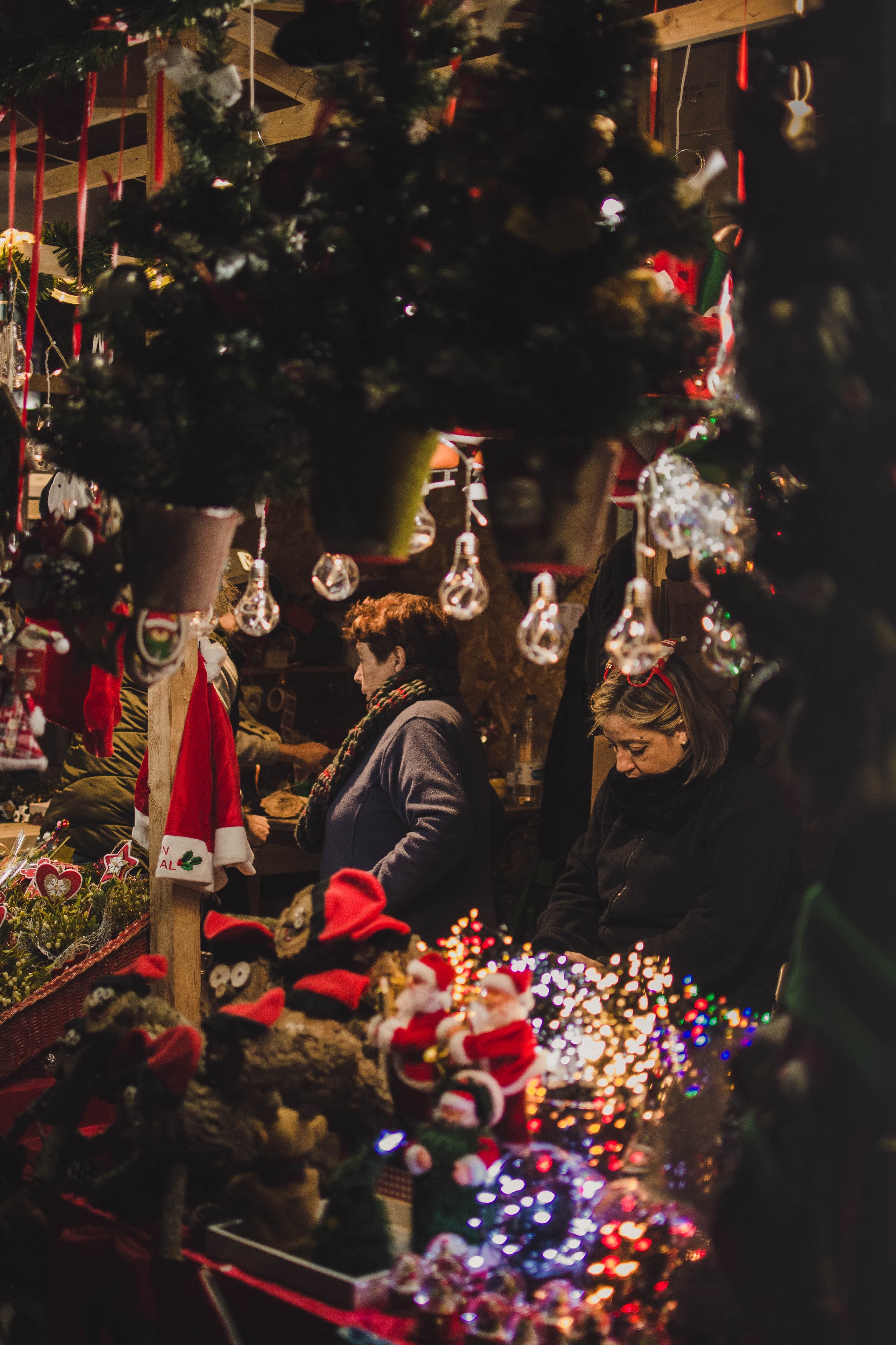 A woman selling ornaments at a Christmas market in Europe.