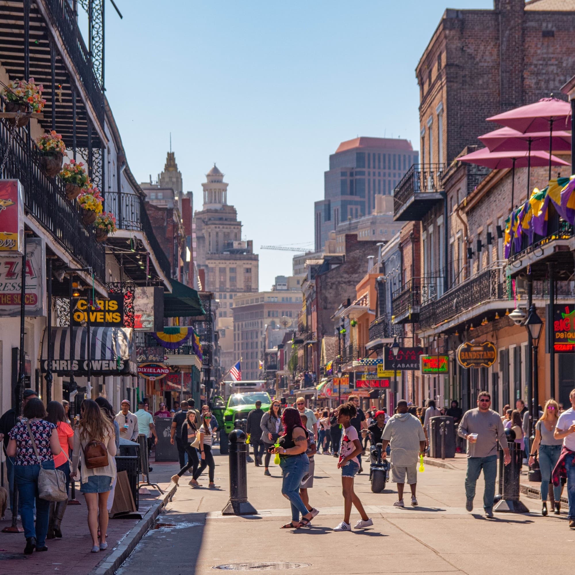 People walking on a street surrounded by shops and cafes.