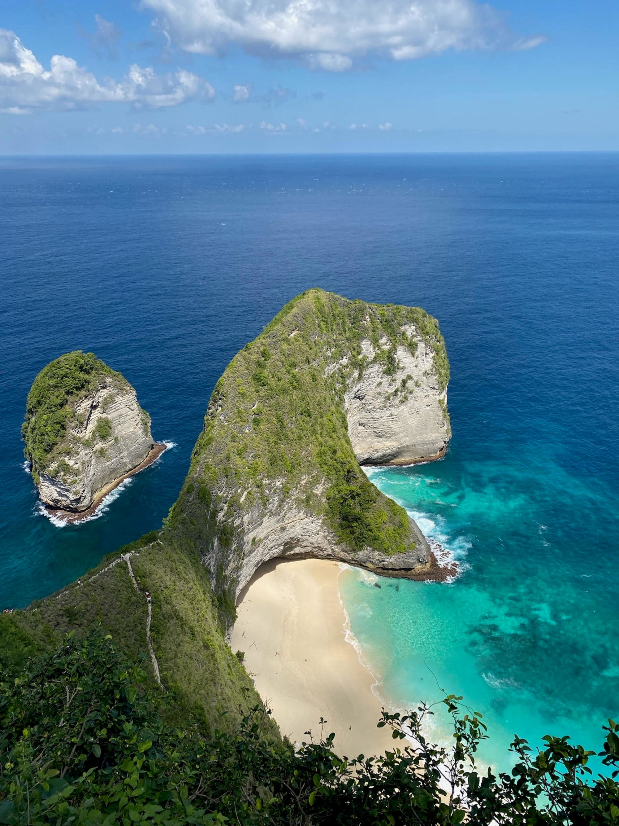 A coastal visage of the T-Rex rock formation that stands guard over a serene beach.
