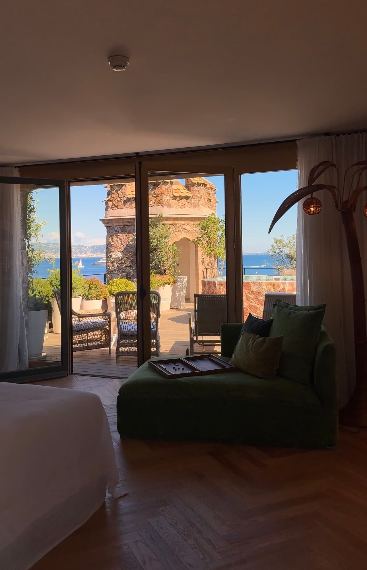 A window of a hotel room offering a view of the sea
