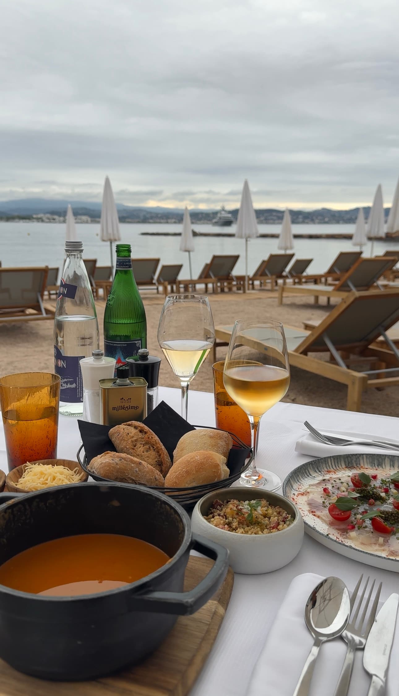 A spread of food on an outdoor table on the beach during the daytime