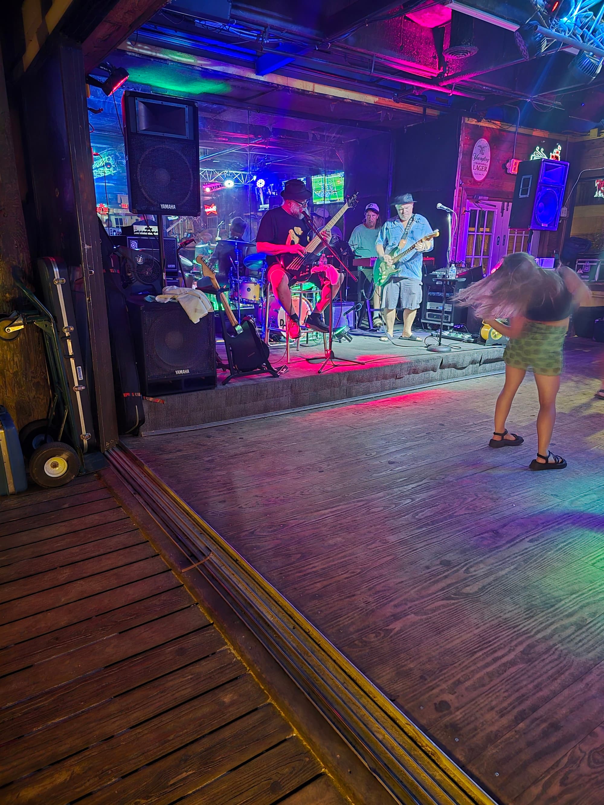 The inside of a bar with a live band playing on a stage