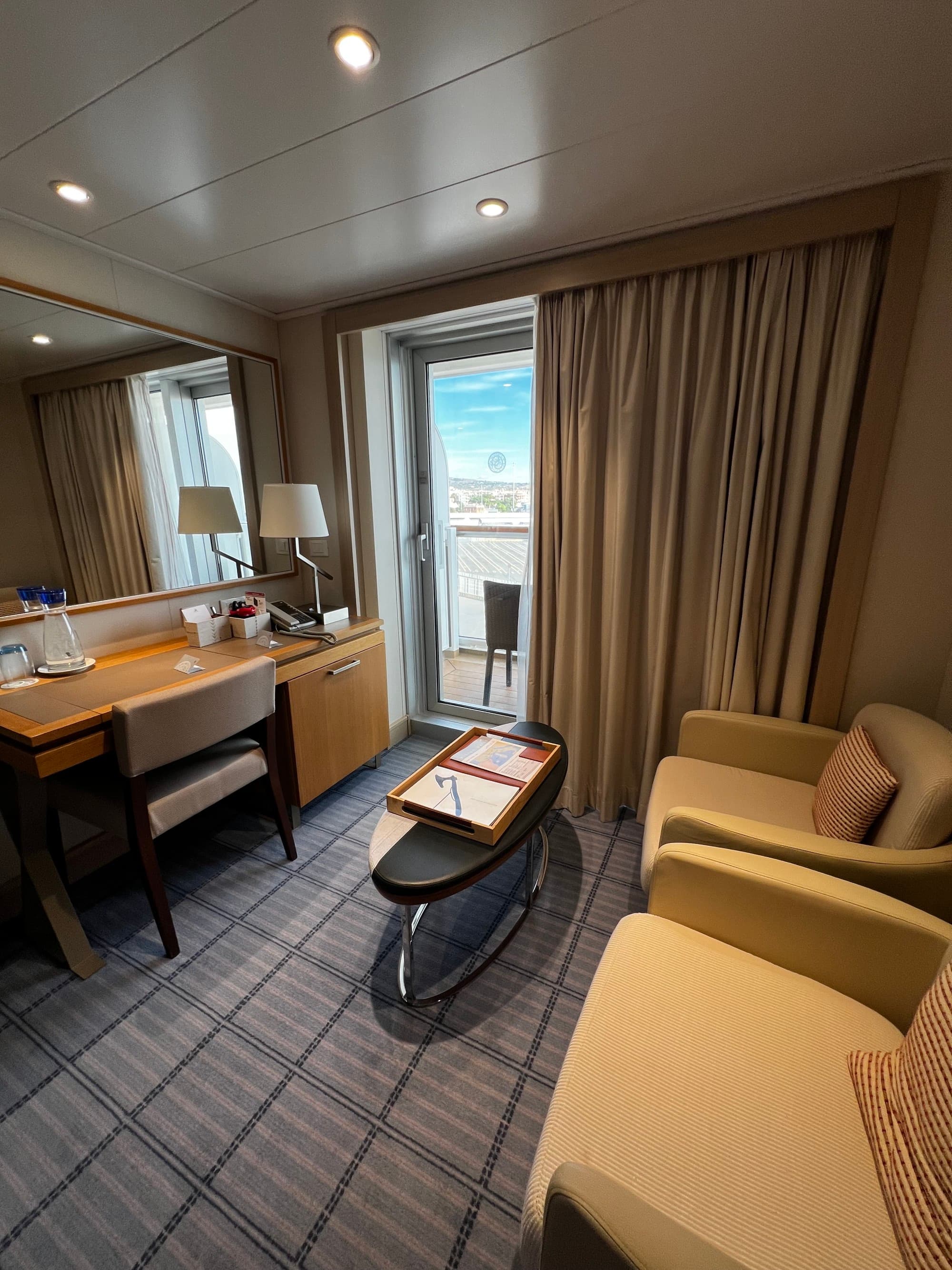Two chairs, a table and a desk in a hotel room