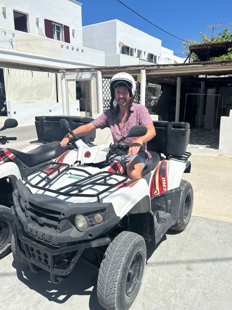 A man posing on a quad bike.