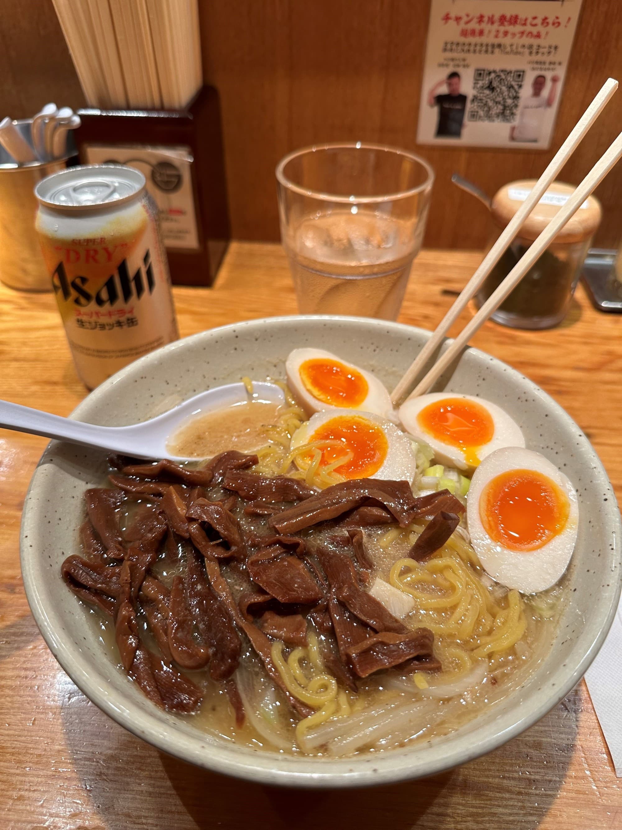 A bowl of ramen noodles with meat and cooked eggs