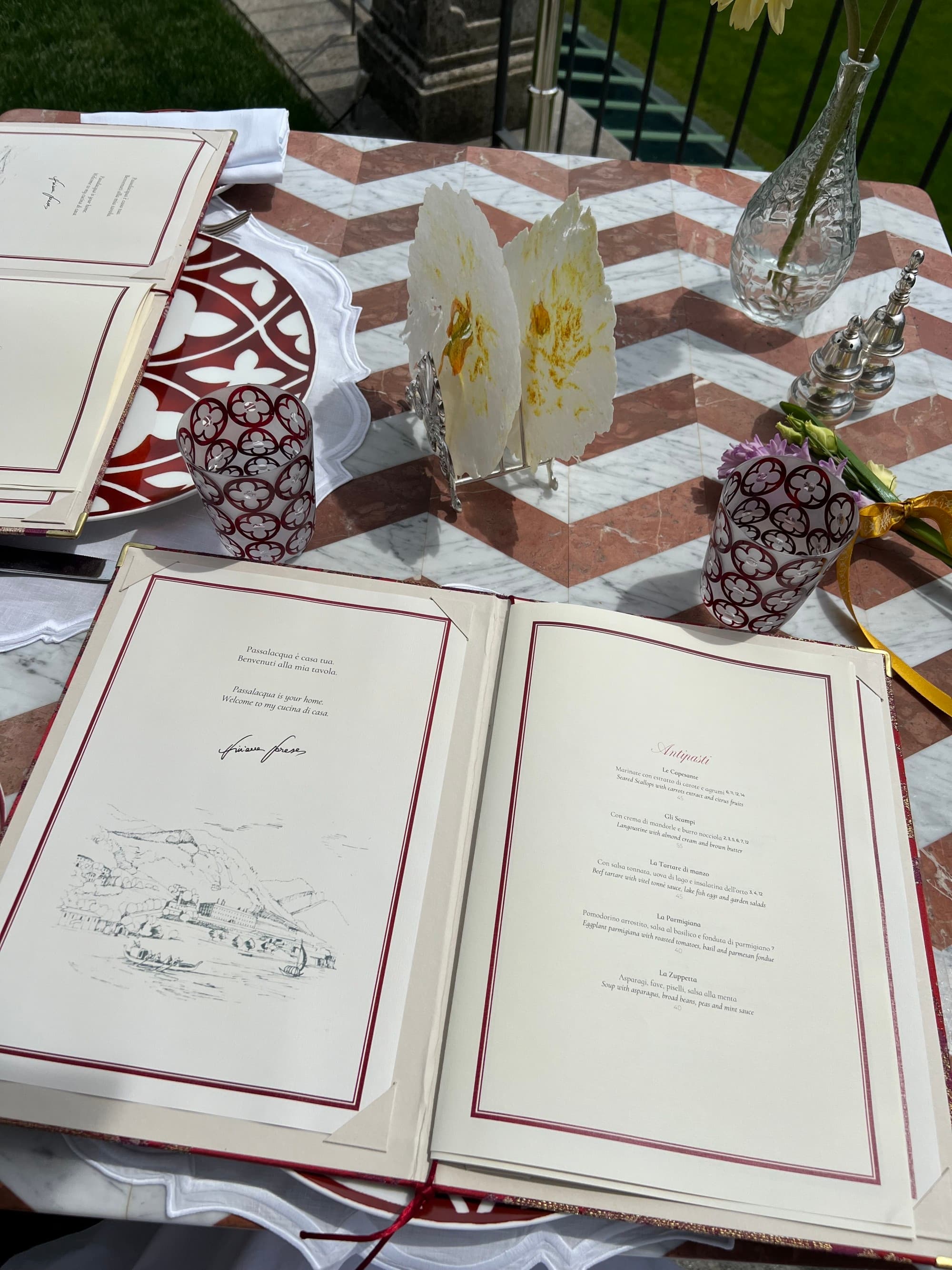 A menu set on a tiled patio table in the sun.