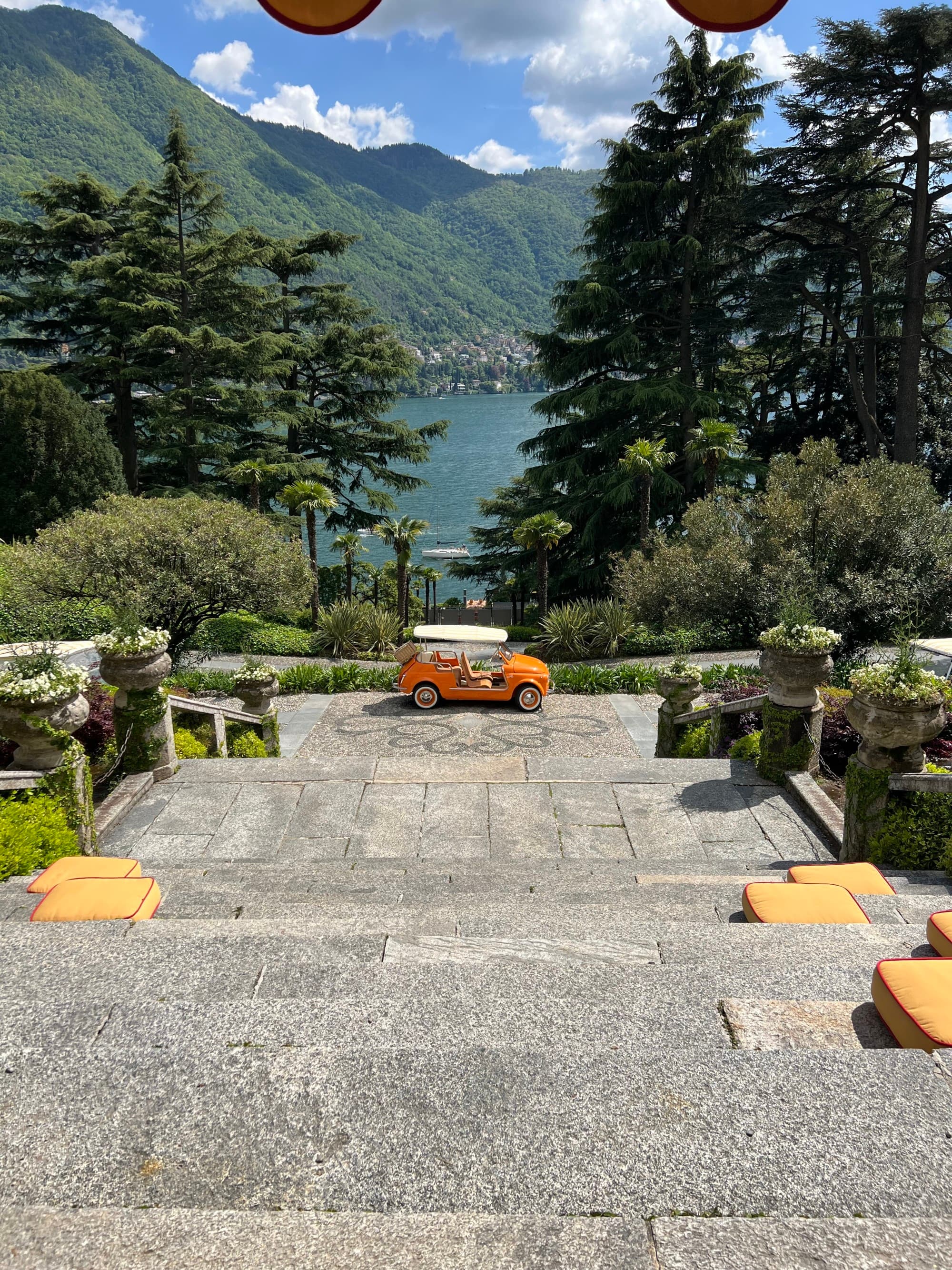 A few of the lake from the top of the stone steps looking onto the trees on a sunny day.