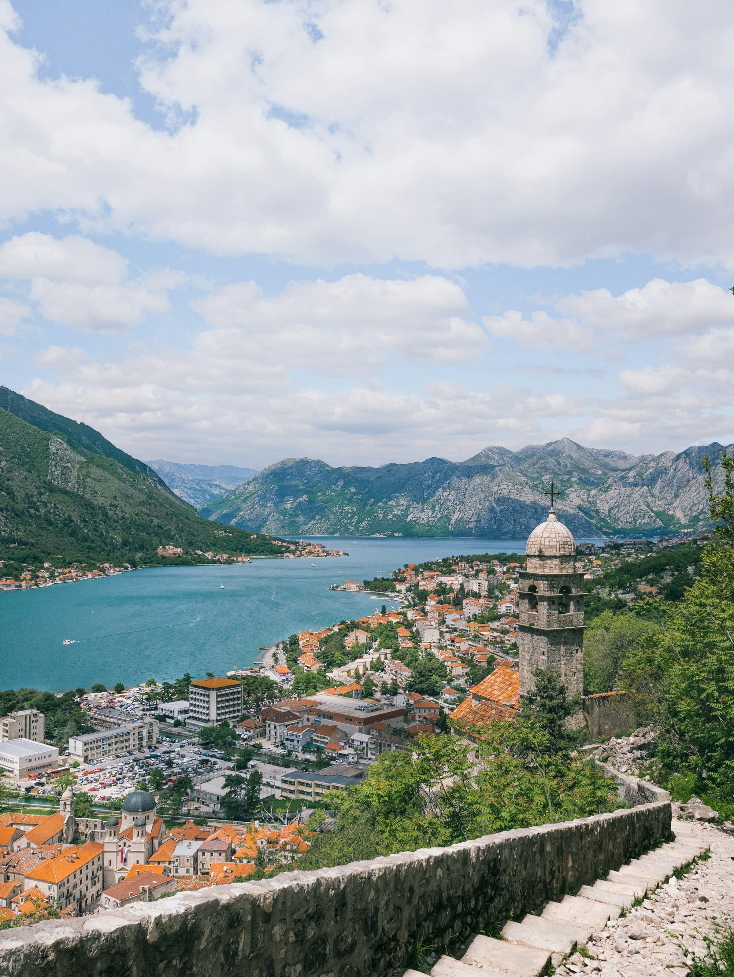 View at the top of the Old Kotor Fort of buildings next to the river between mountains.