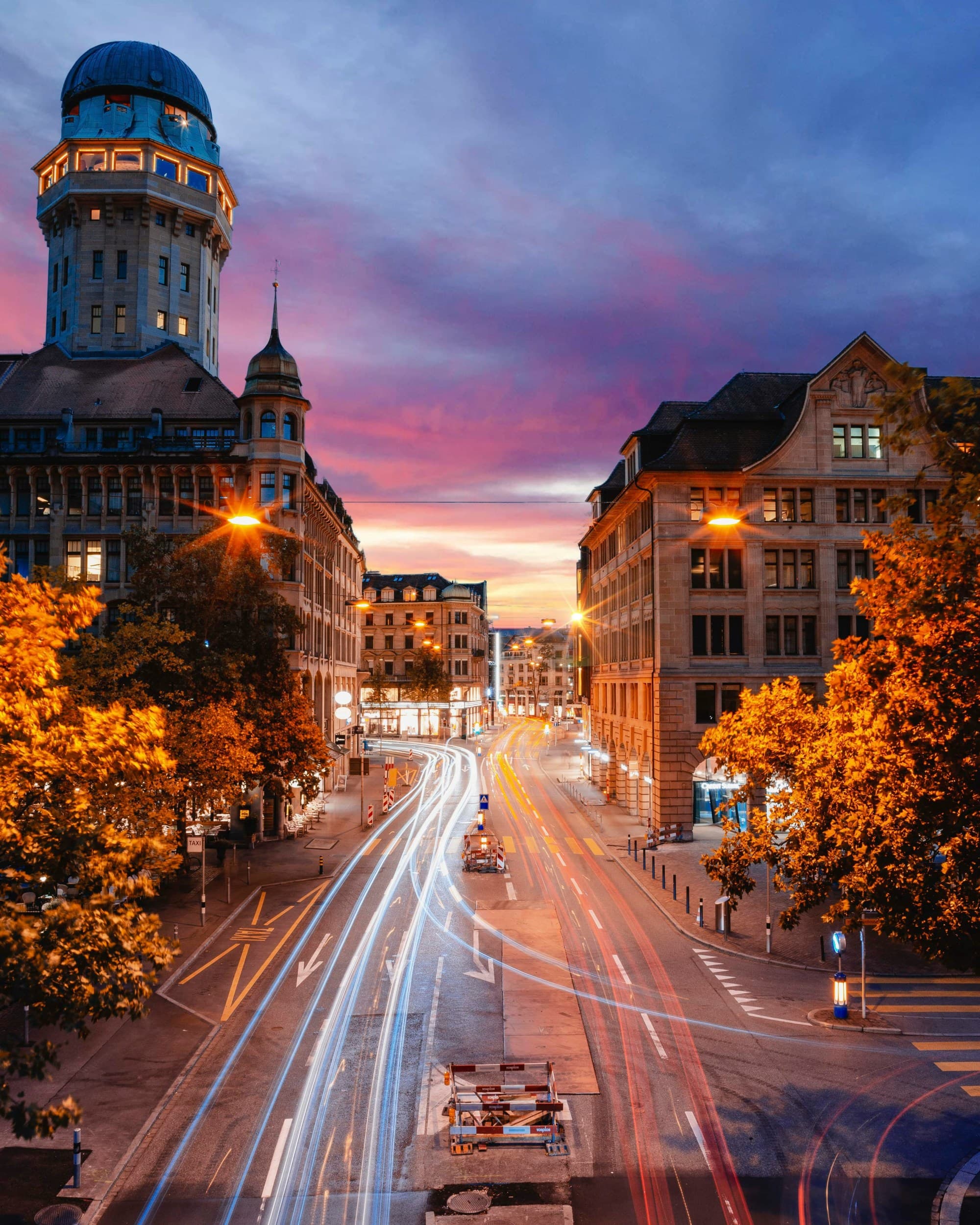 A vibrant cityscape at twilight with light trails from moving vehicles, capturing the dynamic urban life.