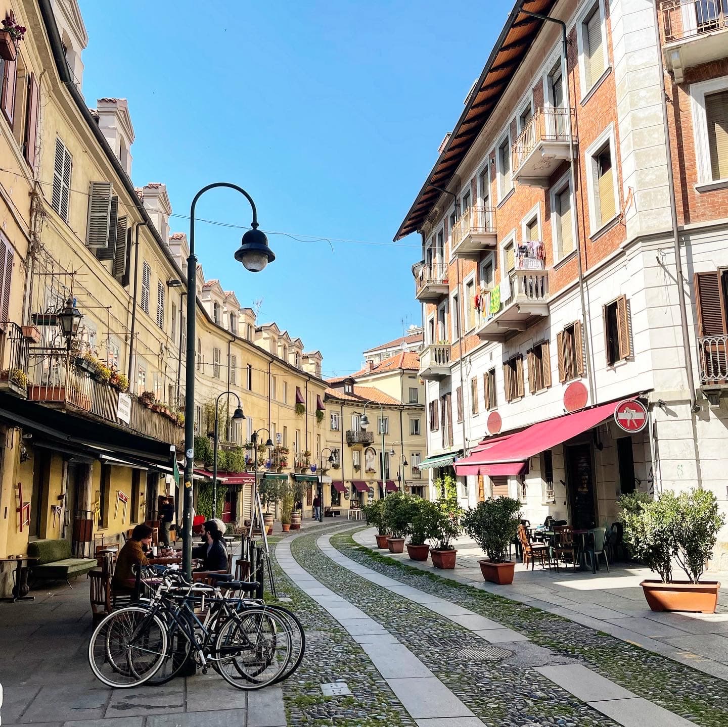 Street view of historical buildings winding along a cobbled street on a clear day.