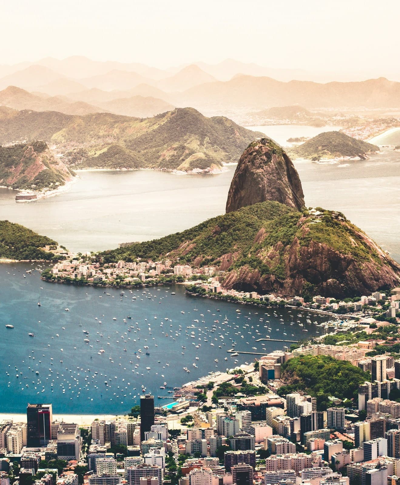 A view of Rio from above with buildings and mountains with water on either side.