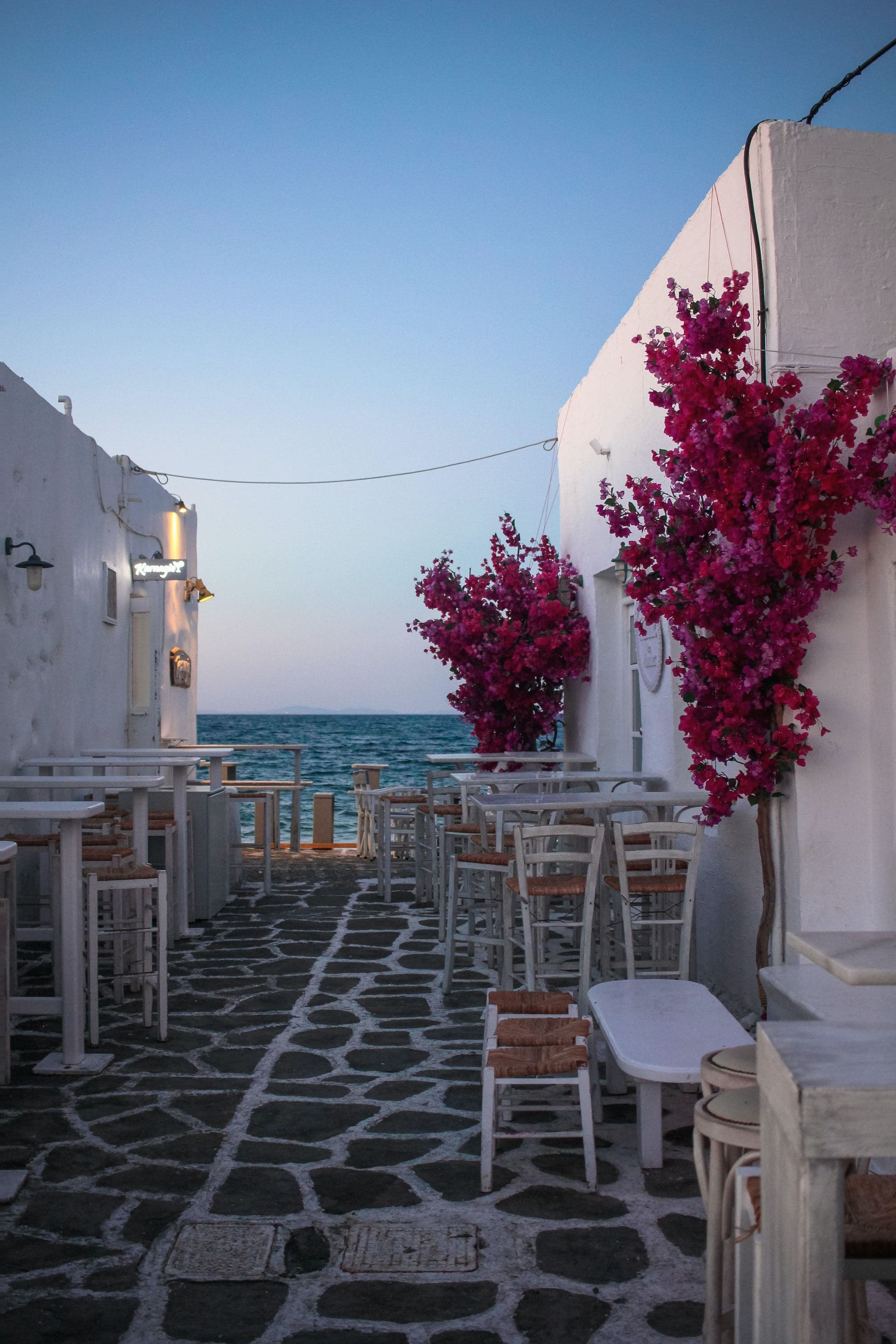 White wooden tables and chairs near body of water