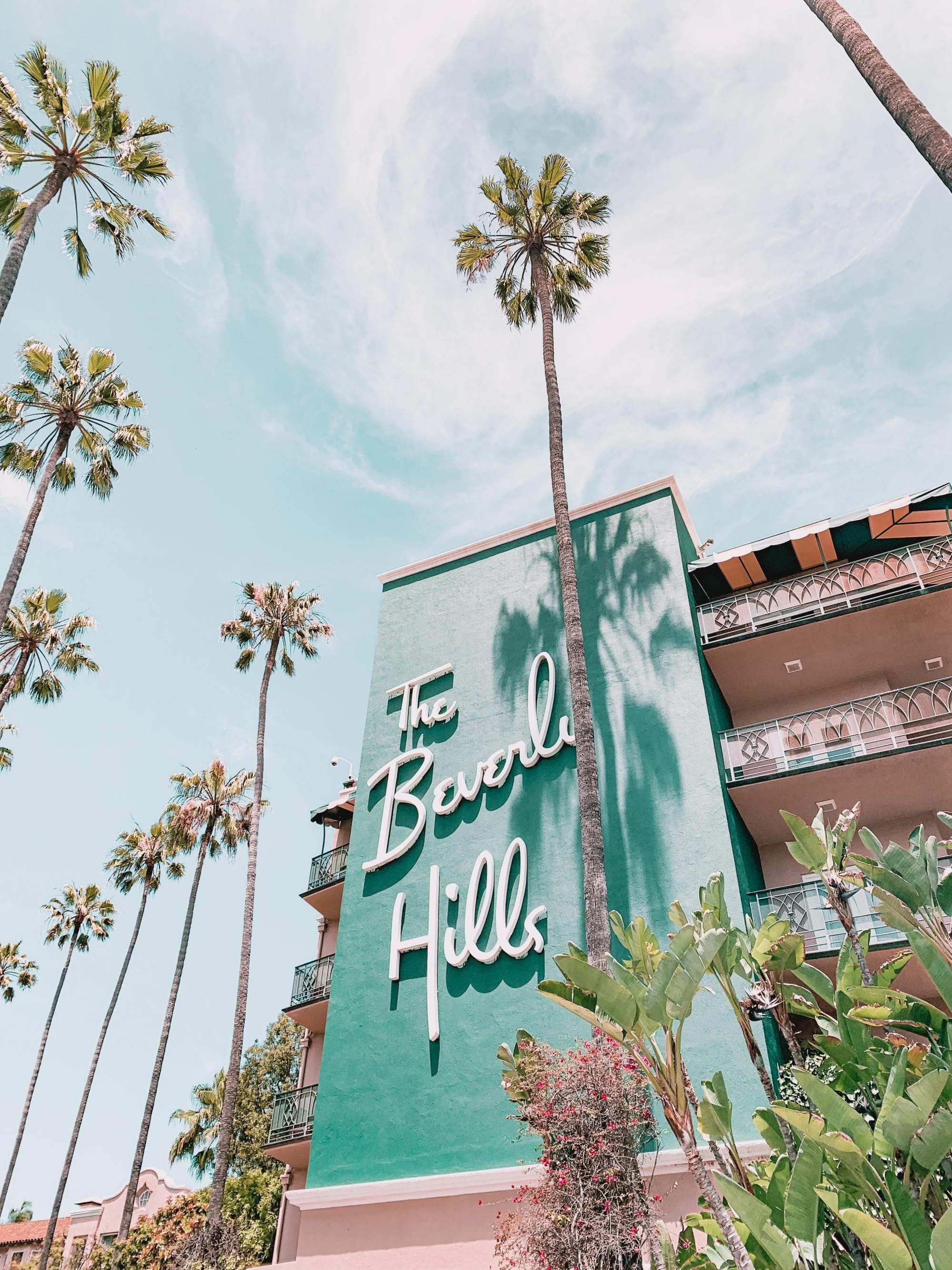 A daytime picture of a building and palm trees.