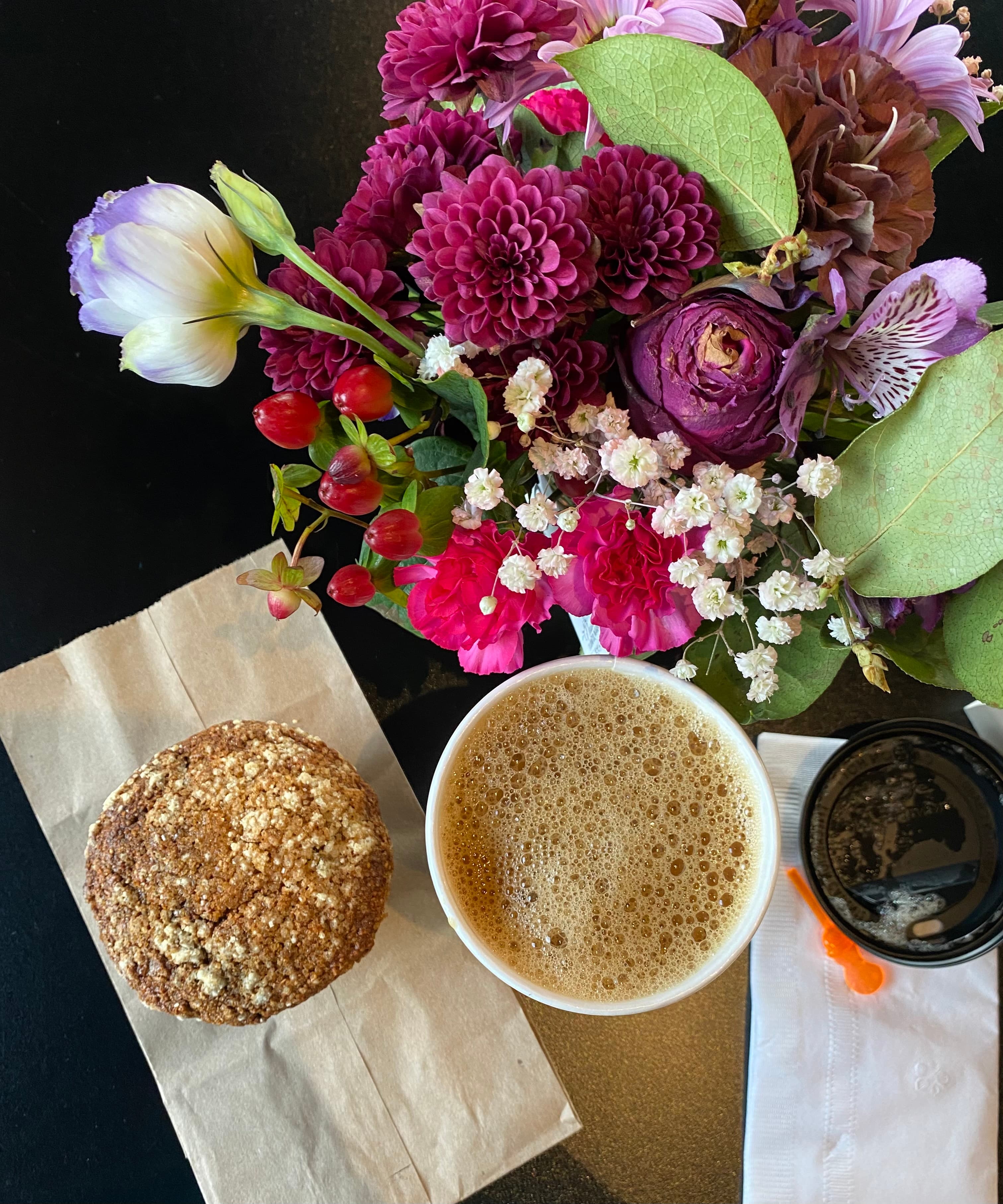 An iced coffee in a plastic to-go cup on a wooden counter.