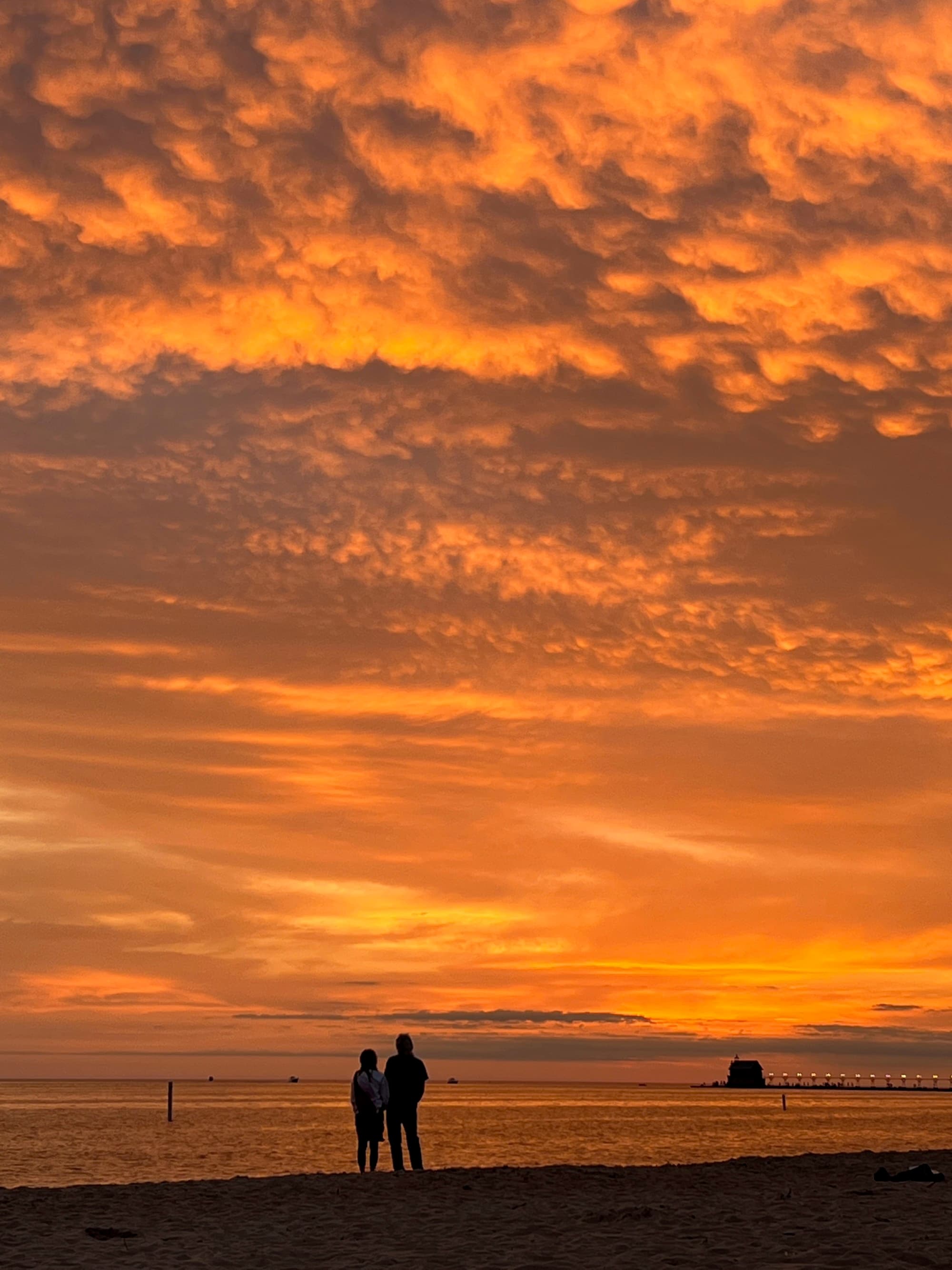 Embrace the breathtaking beauty of a fiery sunset over tranquil waters.