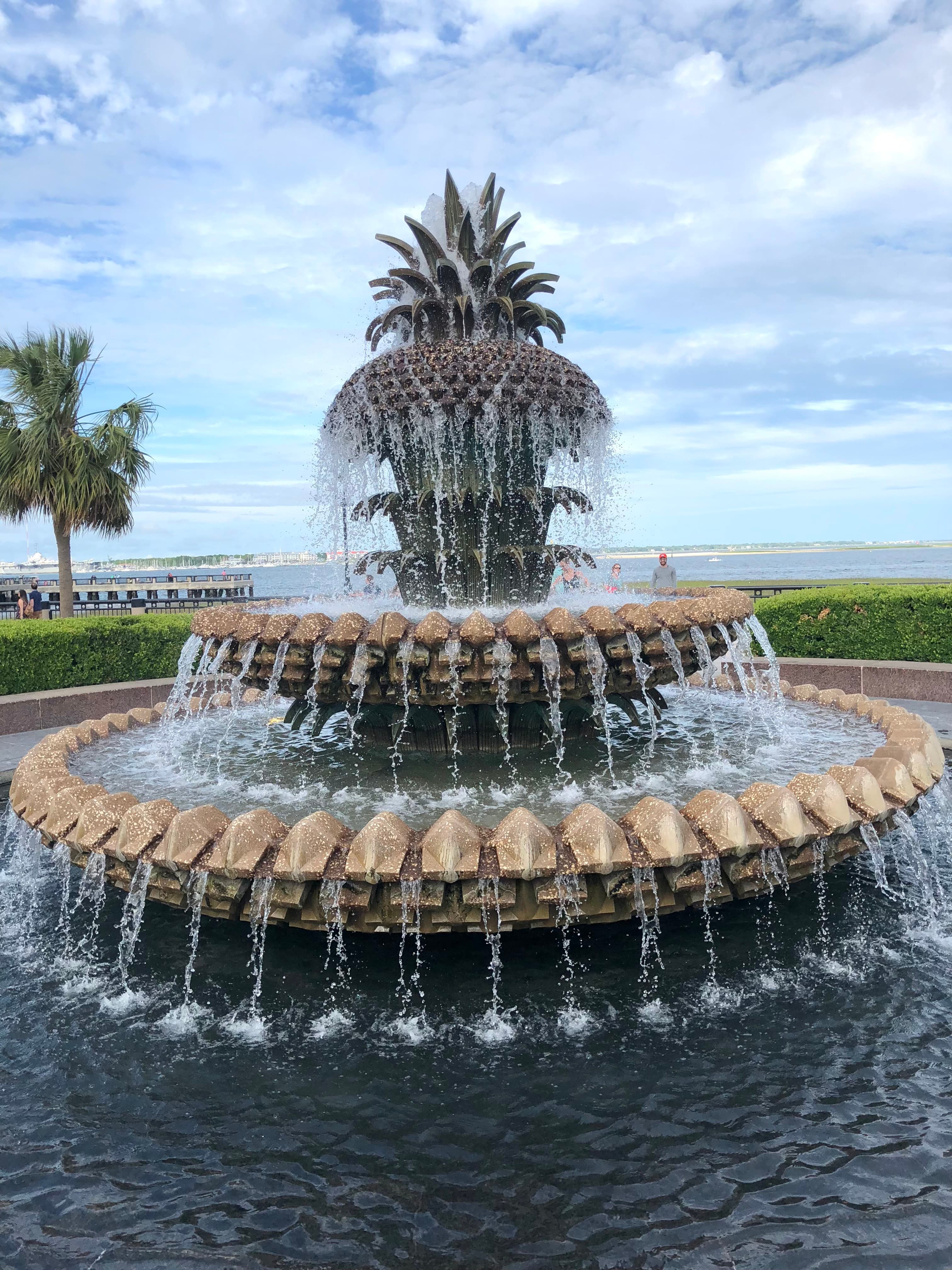 A large water fountain shaped like a pineapple during the daytime