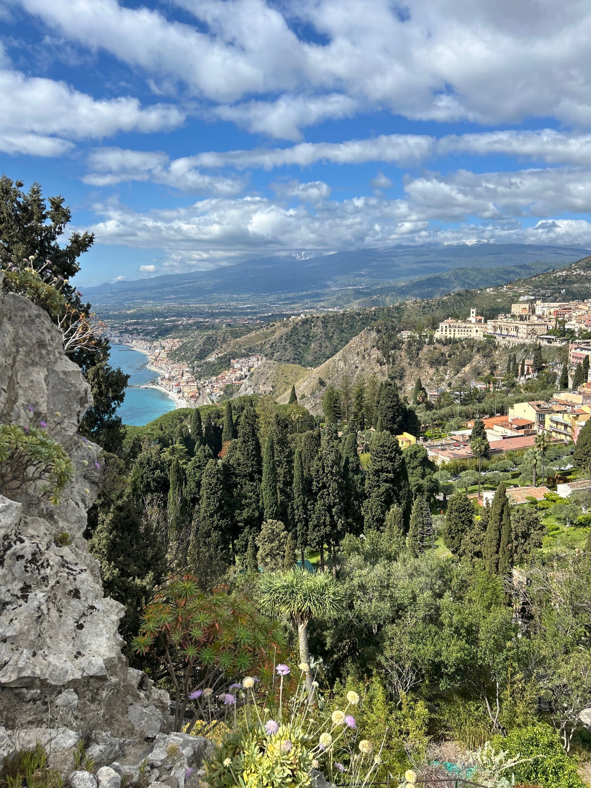 An aerial view of a town surrounded by lush green forests, part of a a 7-day Sicily itinerary