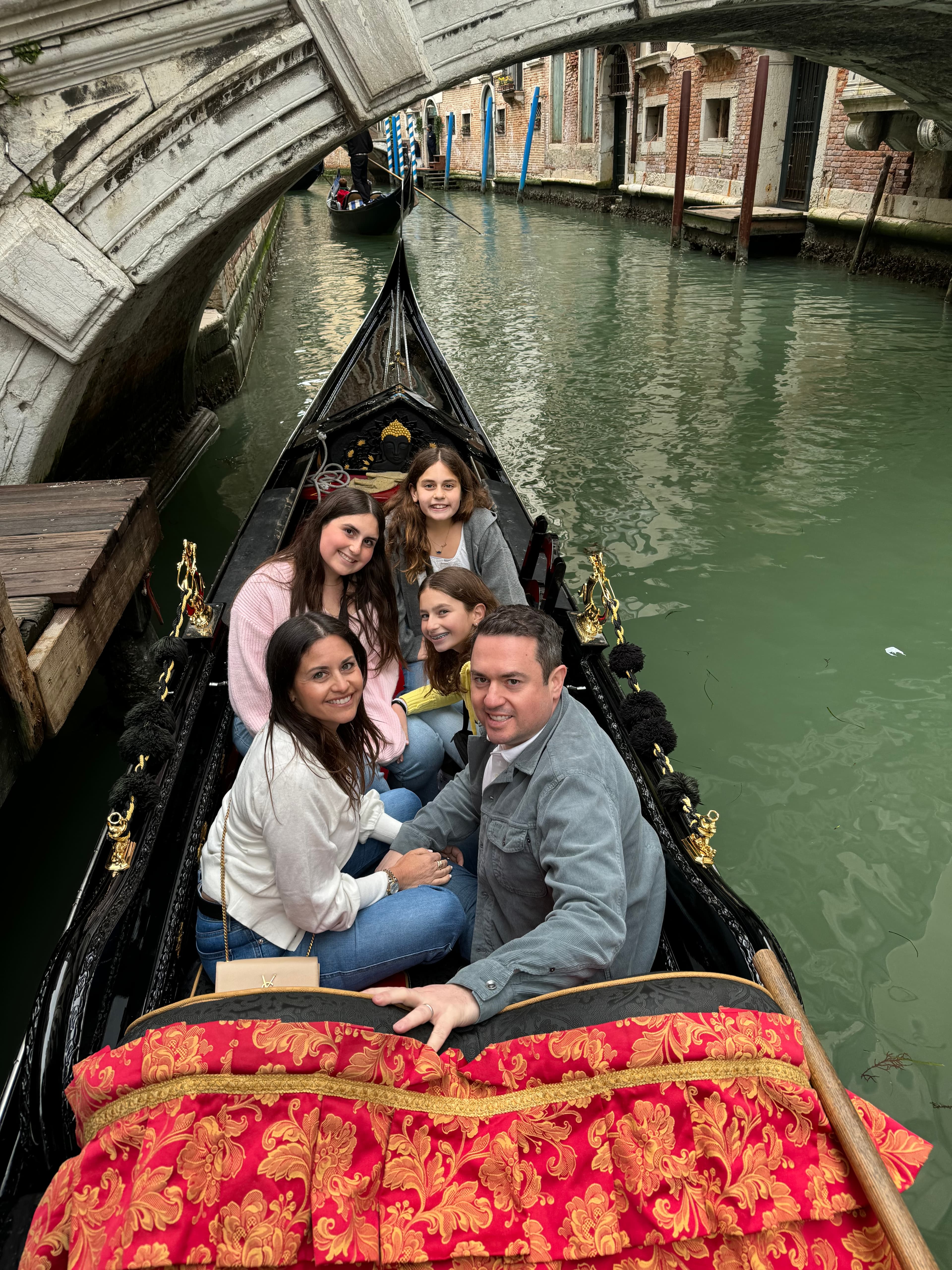 Travel advisor and family floating through the canals of Venice on a gondola.