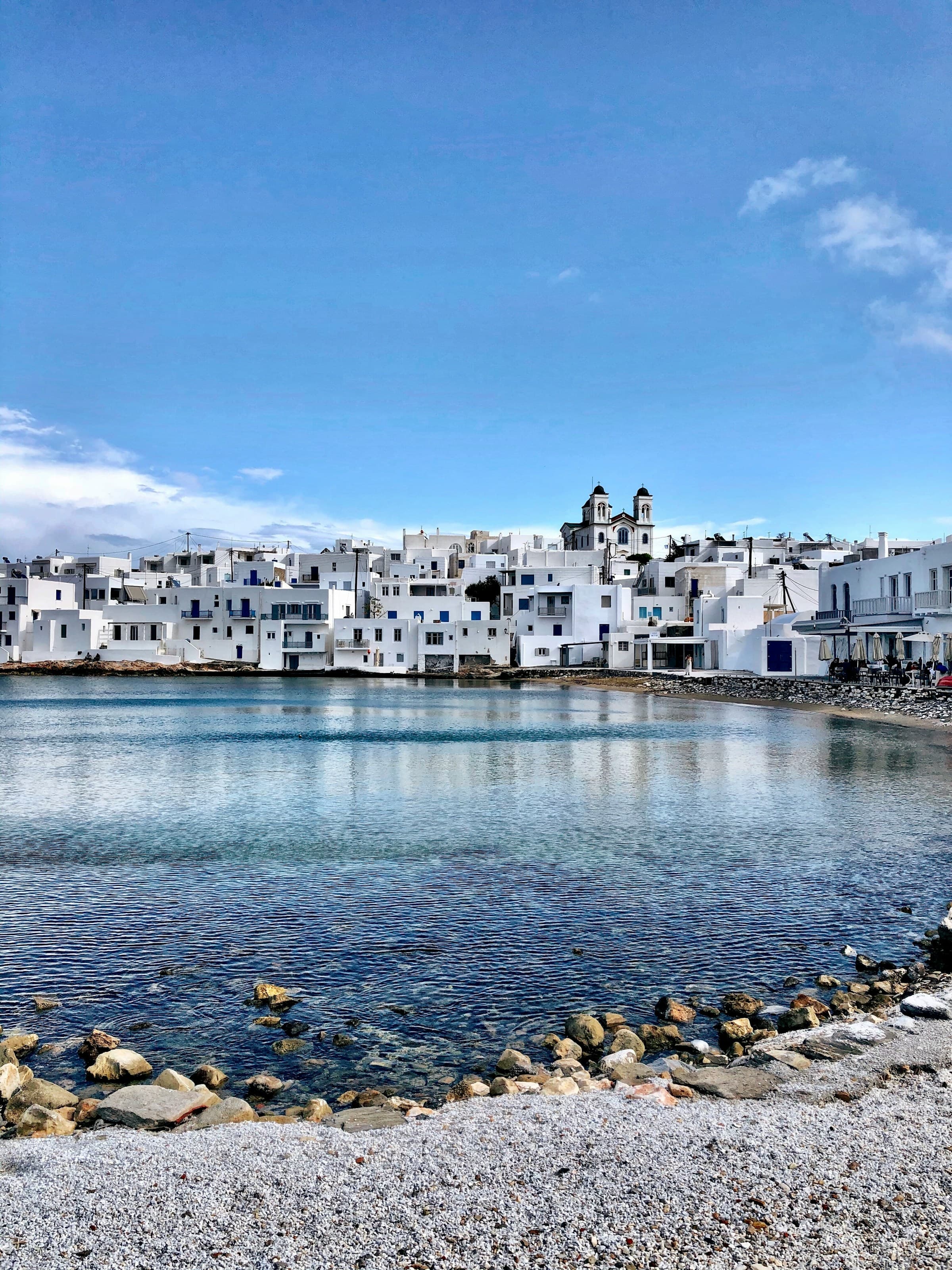 A view of white buildings across a body of water during the daytime