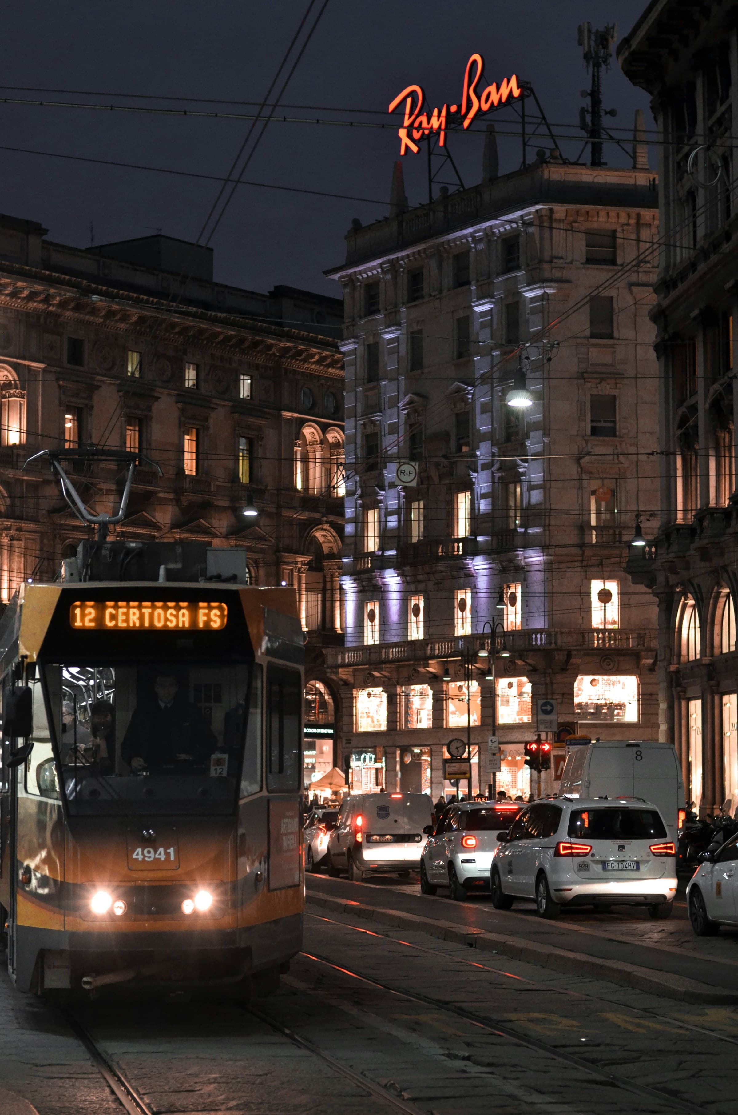 A tram car turning through the nighttime streets of Milan, Italy.