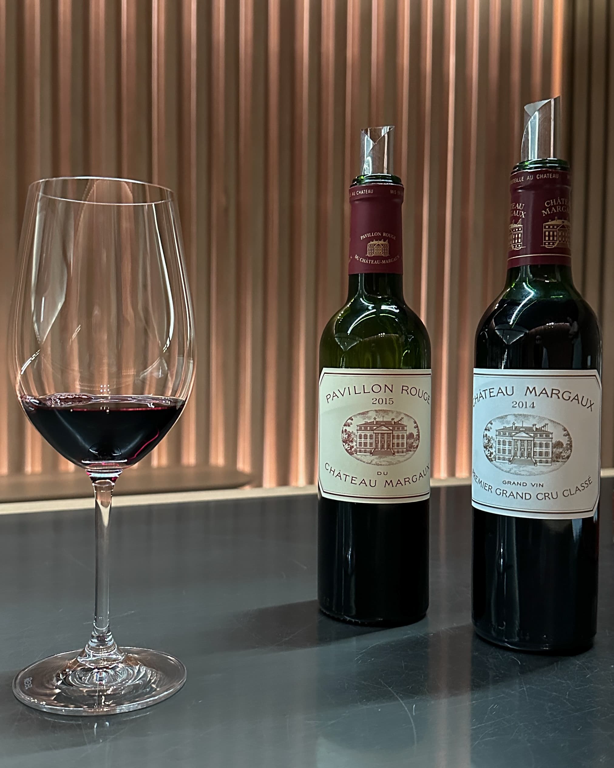 Wine glasses with two bottles of red wine on a sunny day