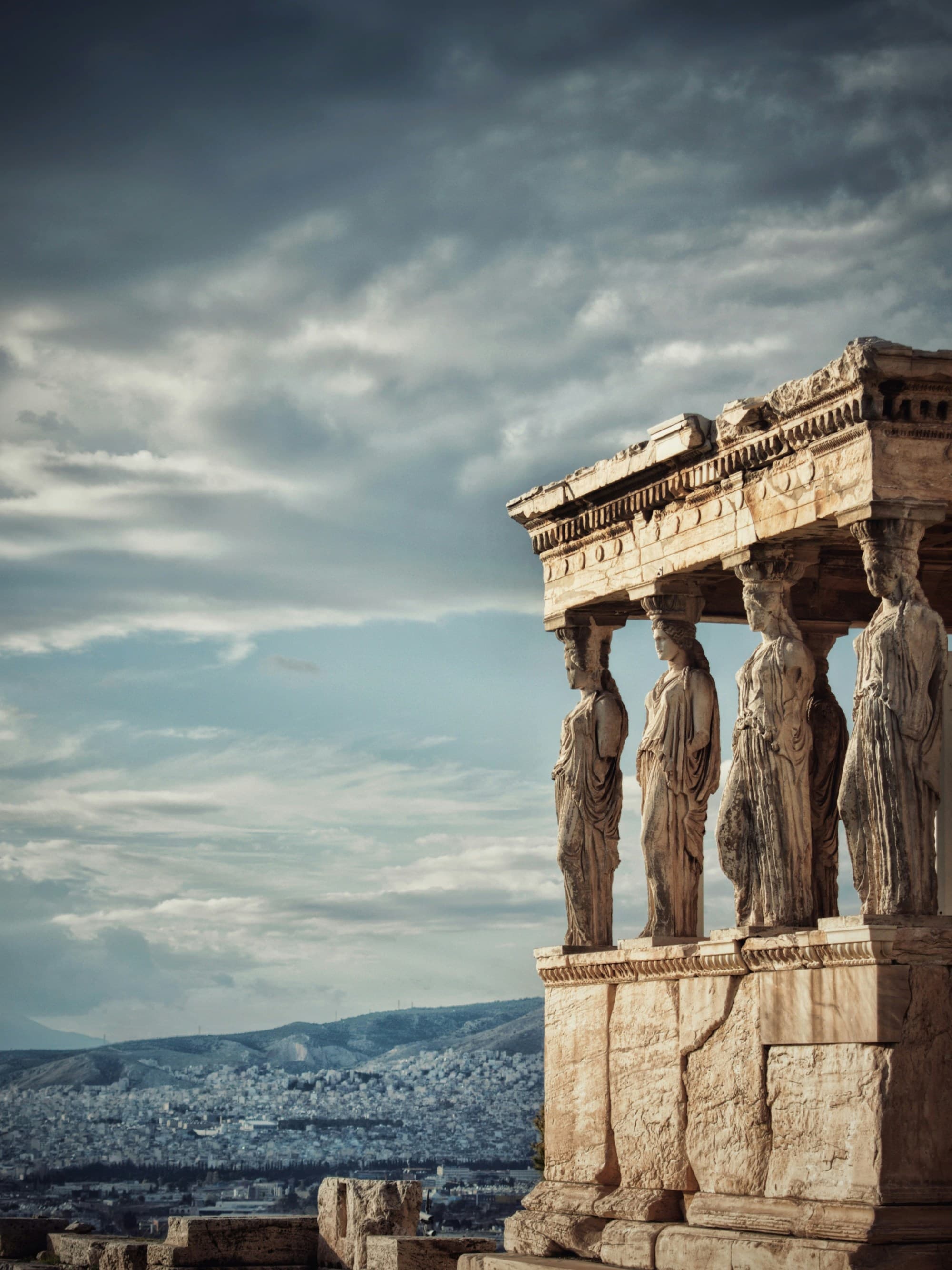 A view of an Ancient Greek statue with clouds in the background.