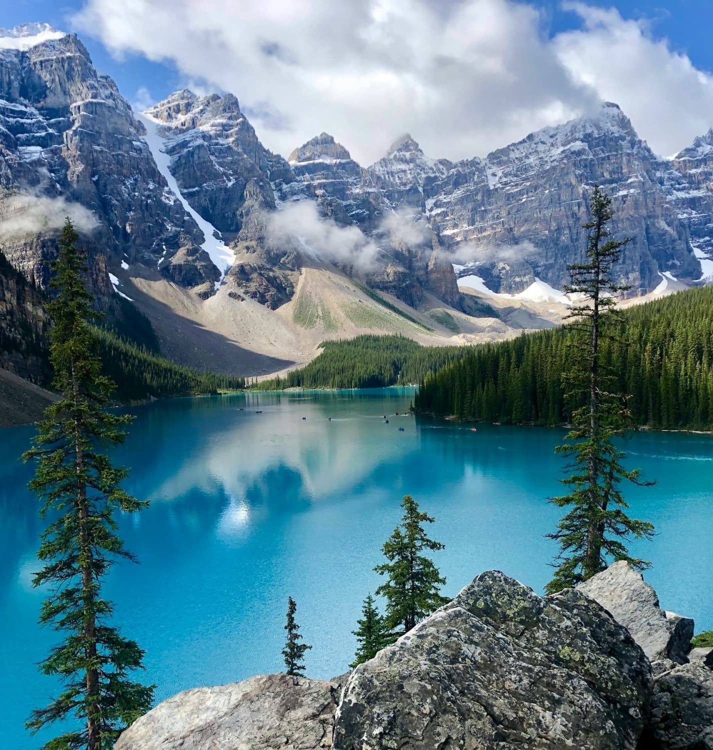 A blue lake surrounded by mountains and trees.