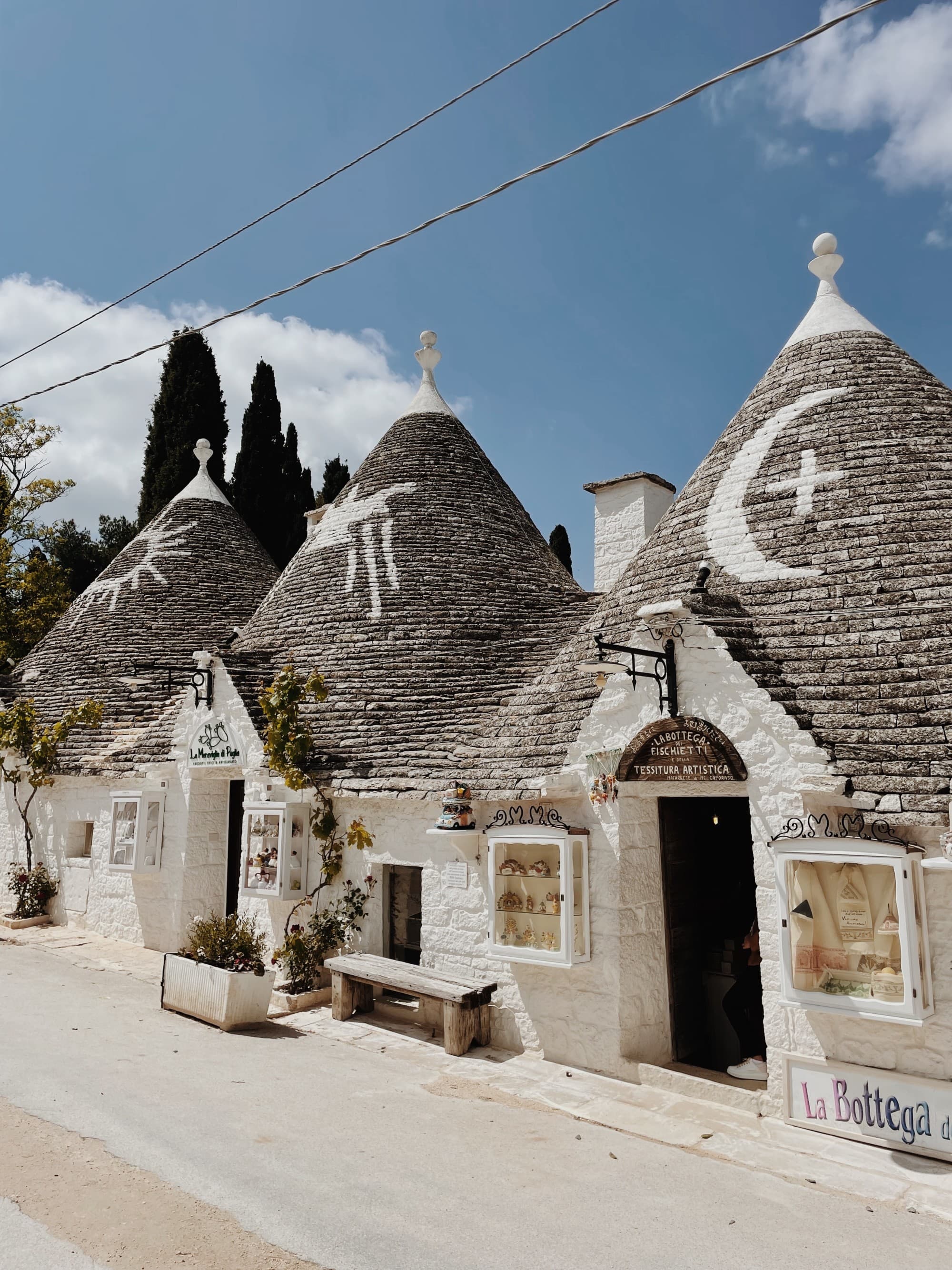 Three hut-like buildings next to a road during the daytime