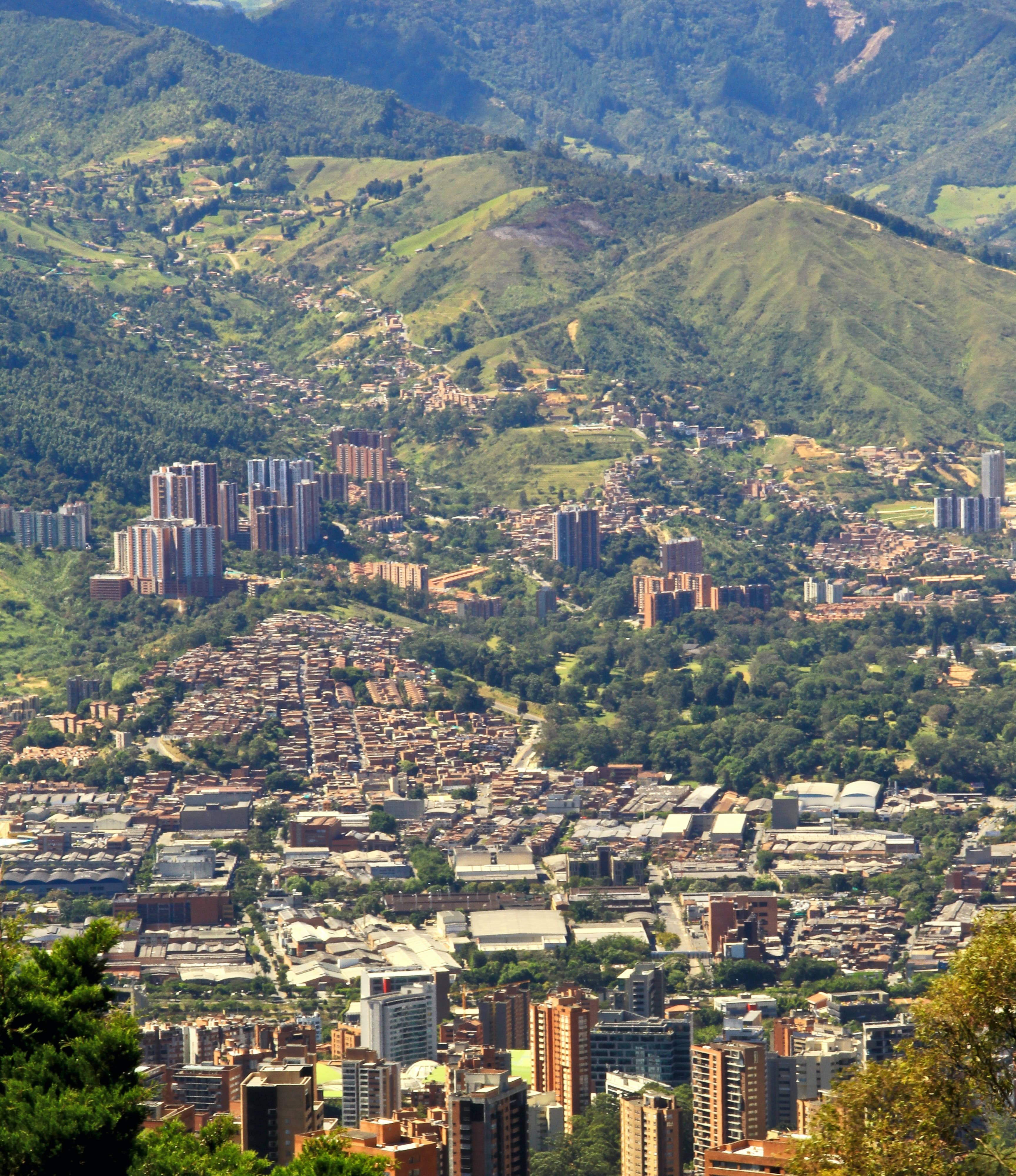 city surrounded by large green mountains