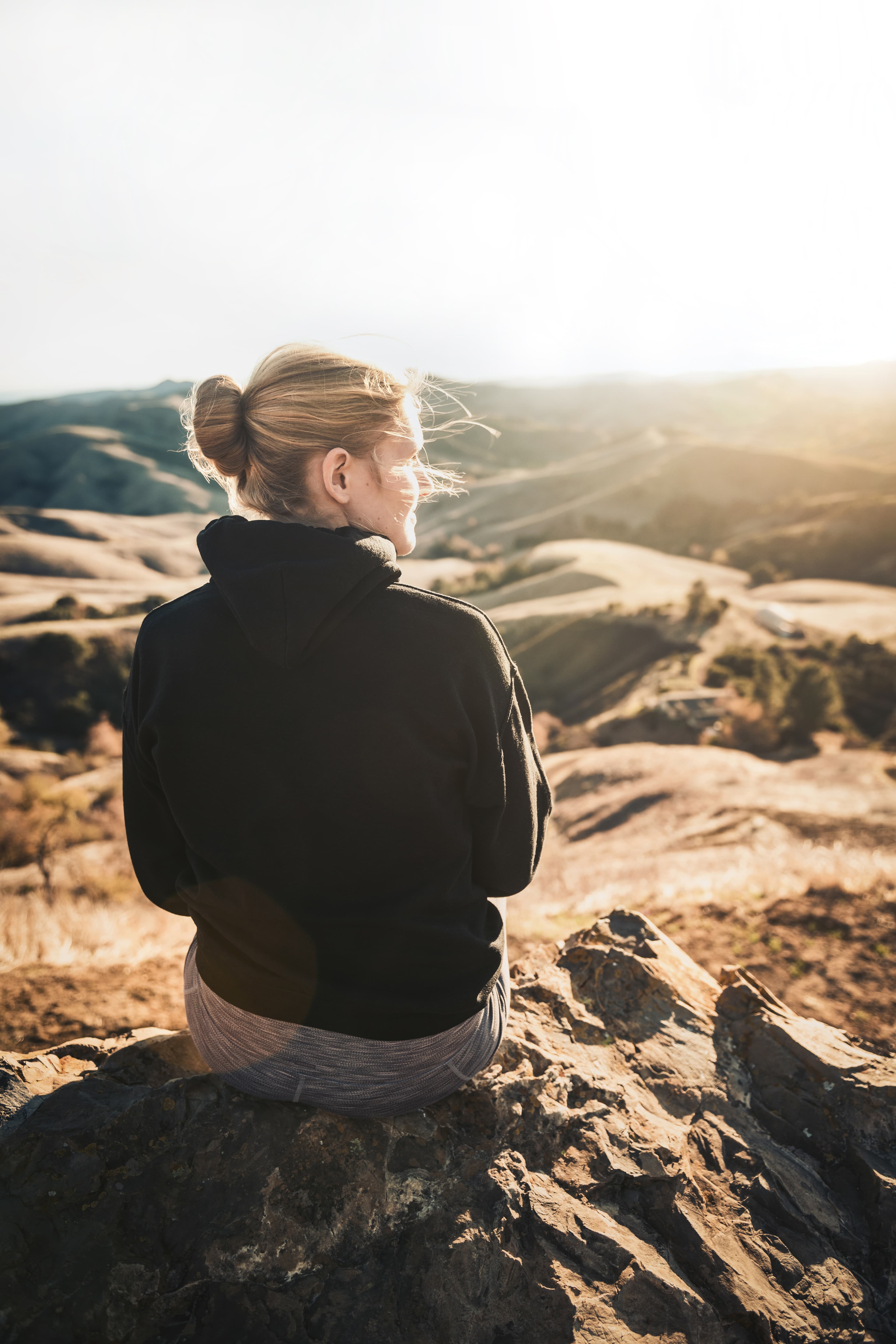 Girl sitting on a mountain.