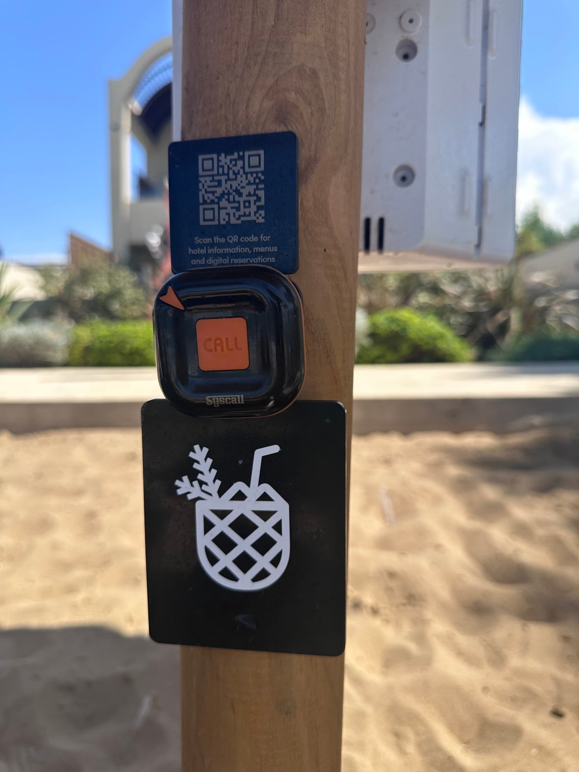 A QR code mounted to a wooden post.