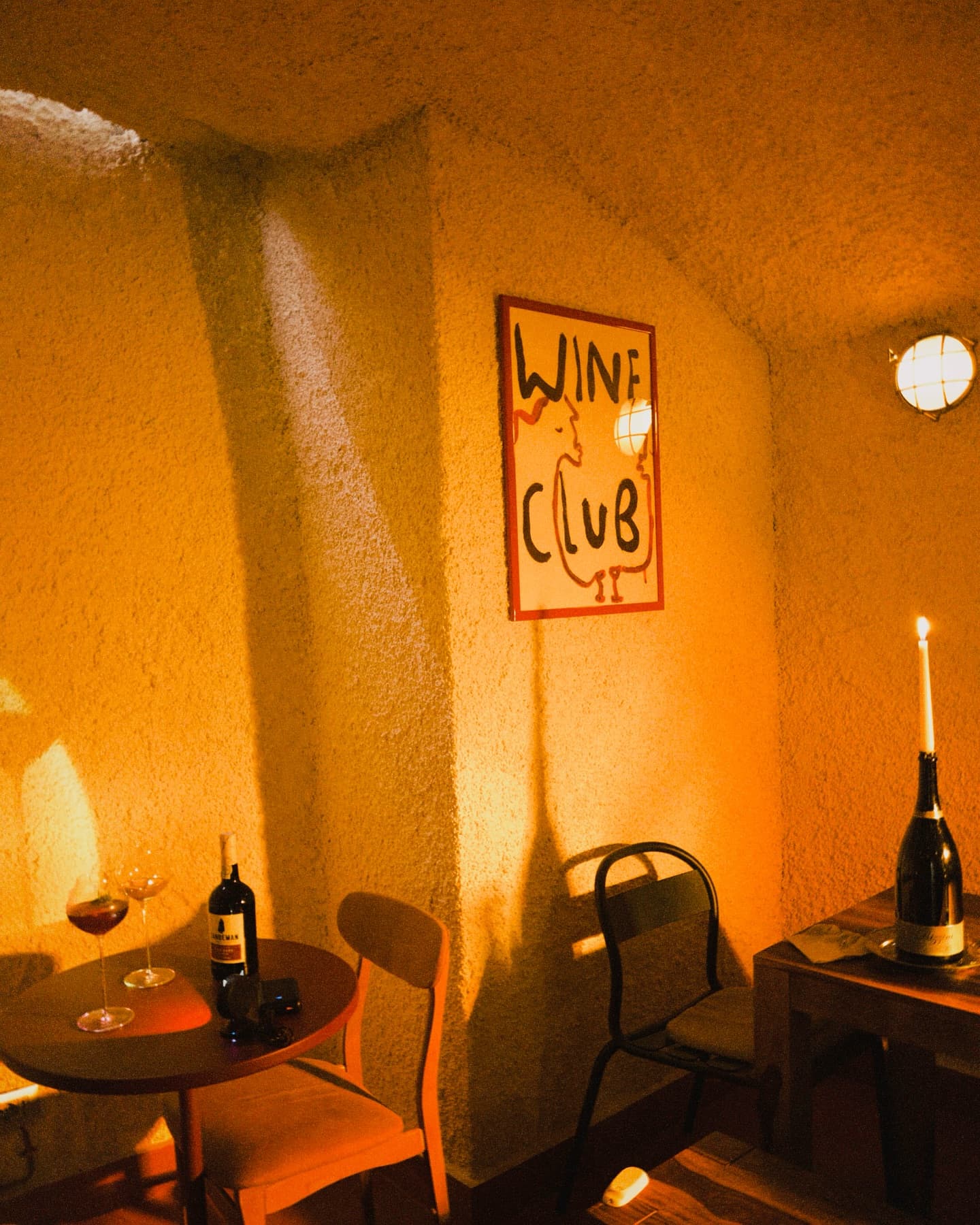 an intimate wine bar with small tables and moody lighting