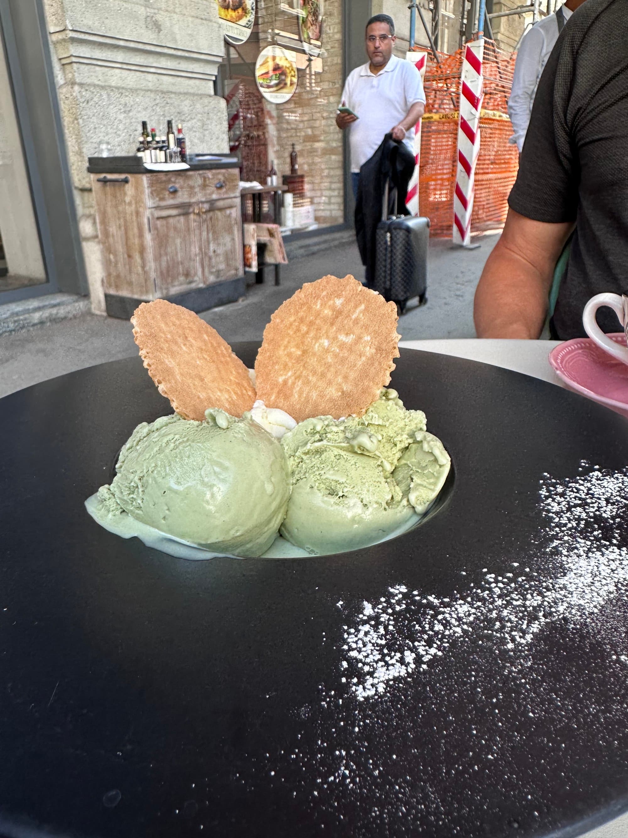 A dish with green pistachio gelato and waffle pieces.
