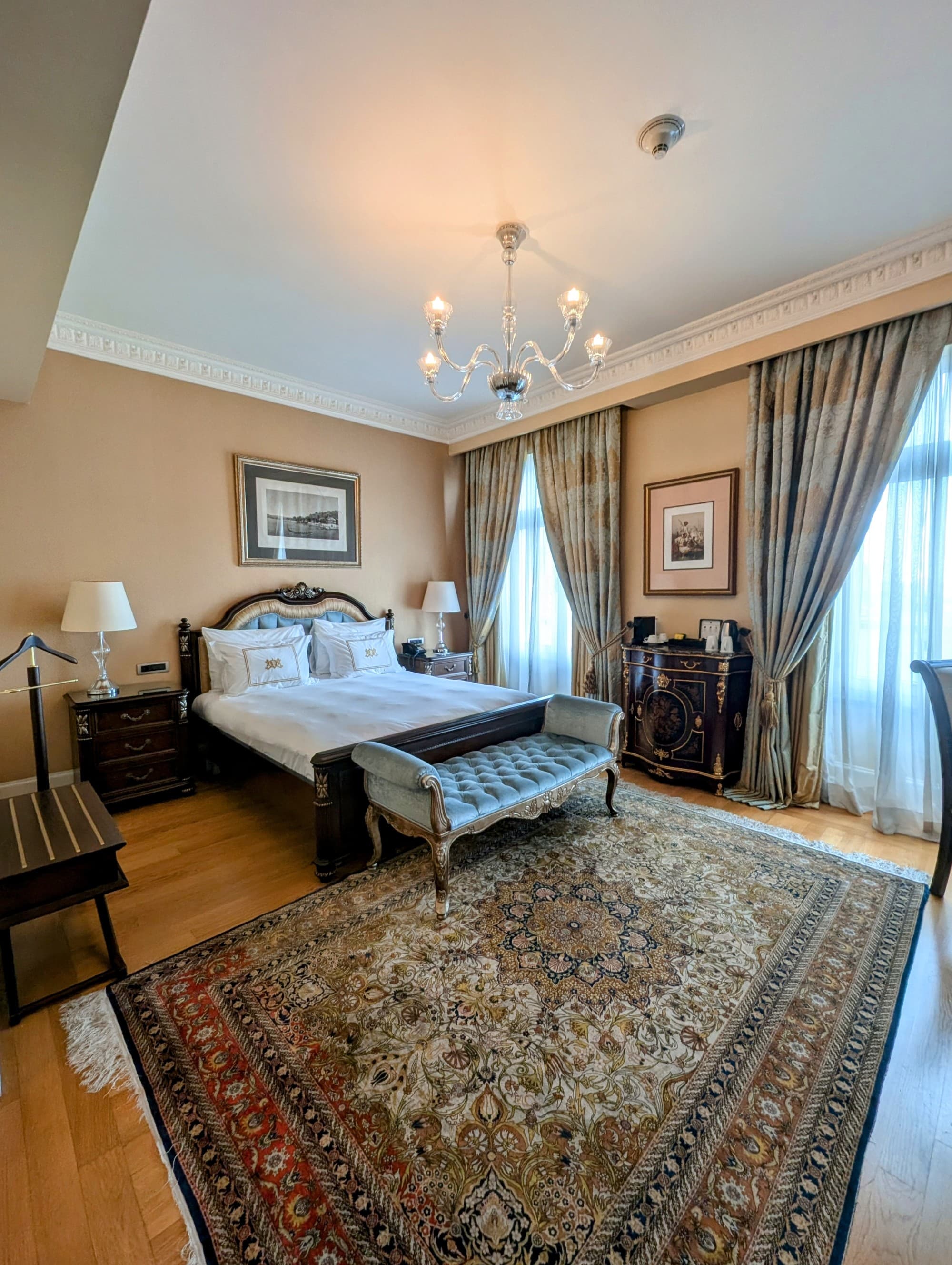 A hotel room with an enormous Turkish rug and a queen-sized bed.
