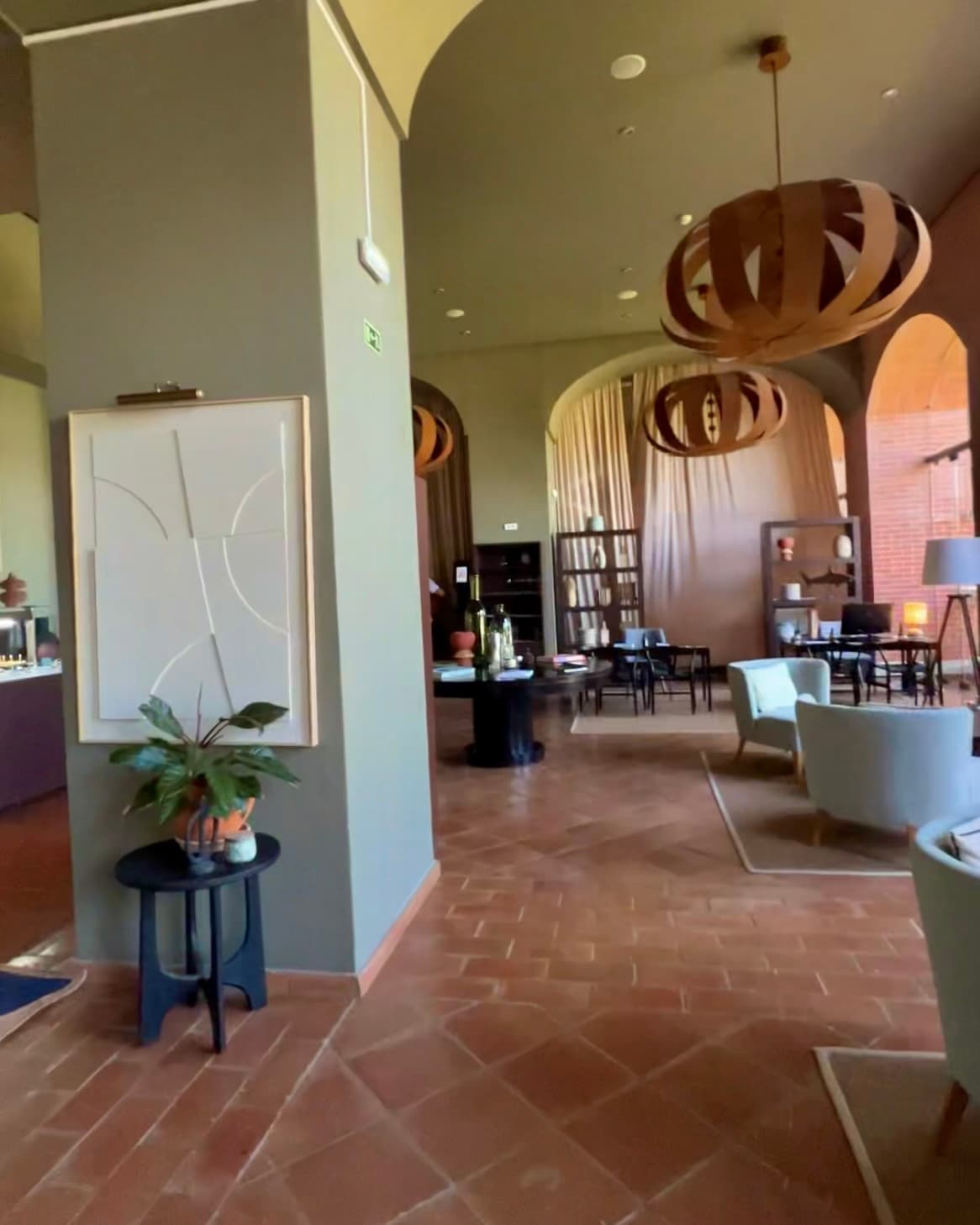 Club Lounge at Domes Lake Algarve with tiled floor, hanging lampshades and lounge seating.