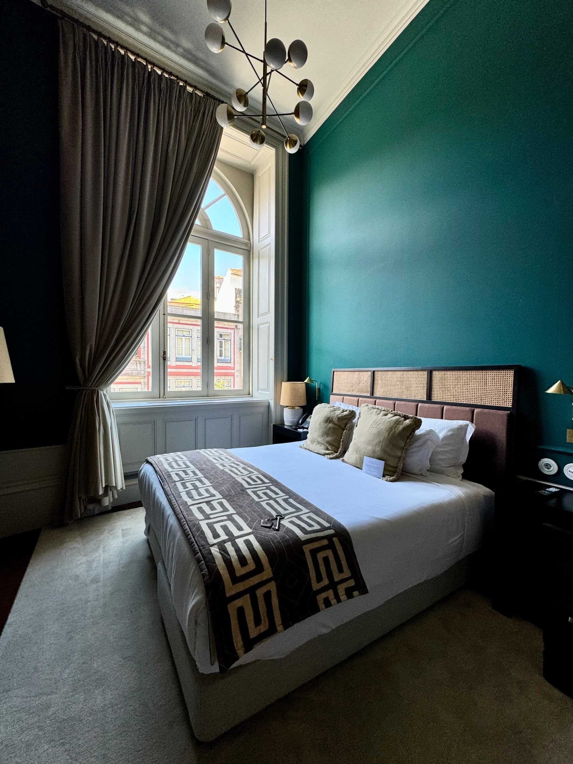 A bed in front of a green-painted wall