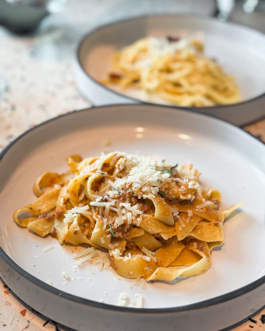 Two plates of pasta on a table
