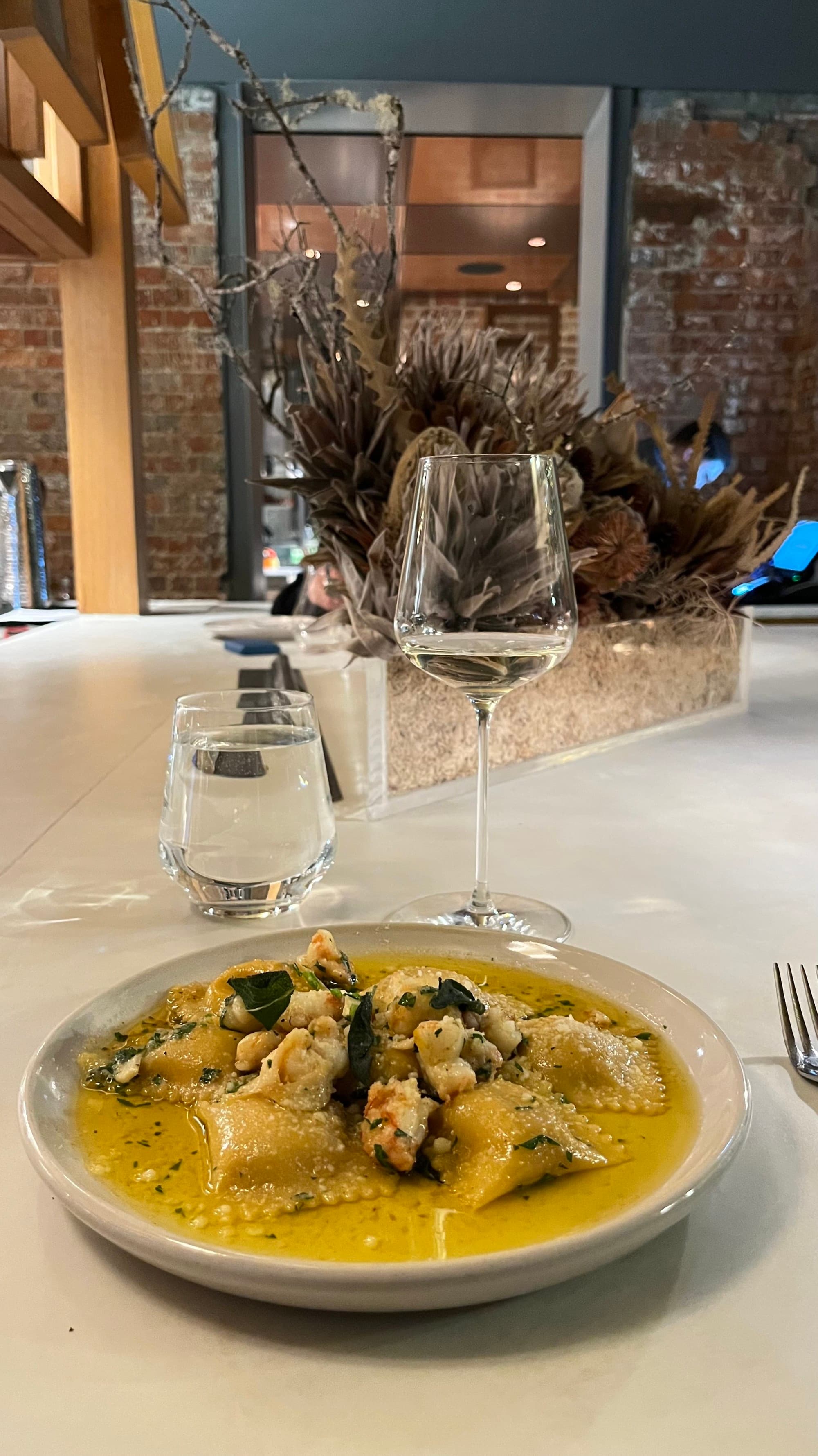Dish of ravioli on a large plate resting on a marble countertop at The Tasman.