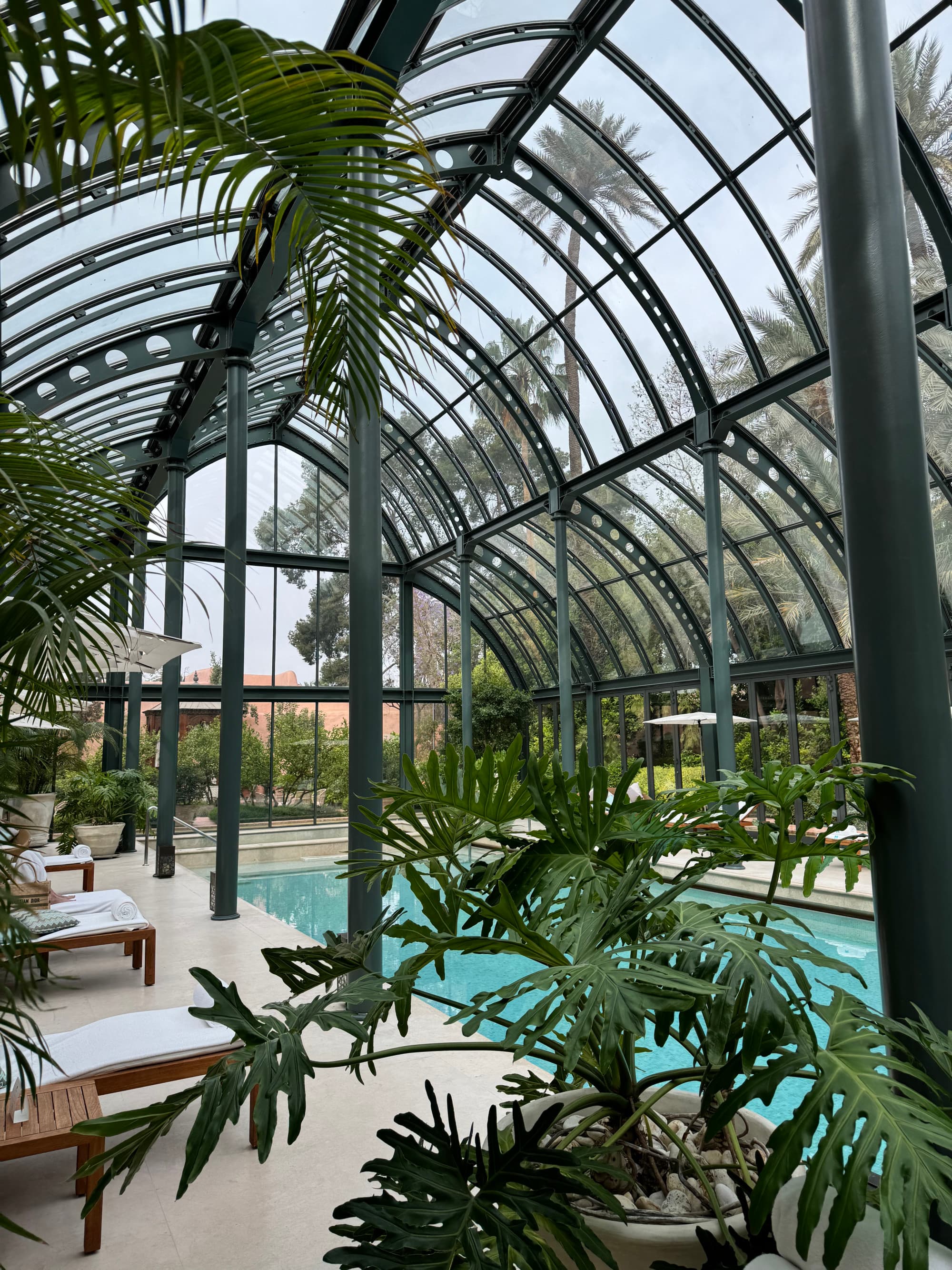 A swimming pool area inside a glass-walled courtyard