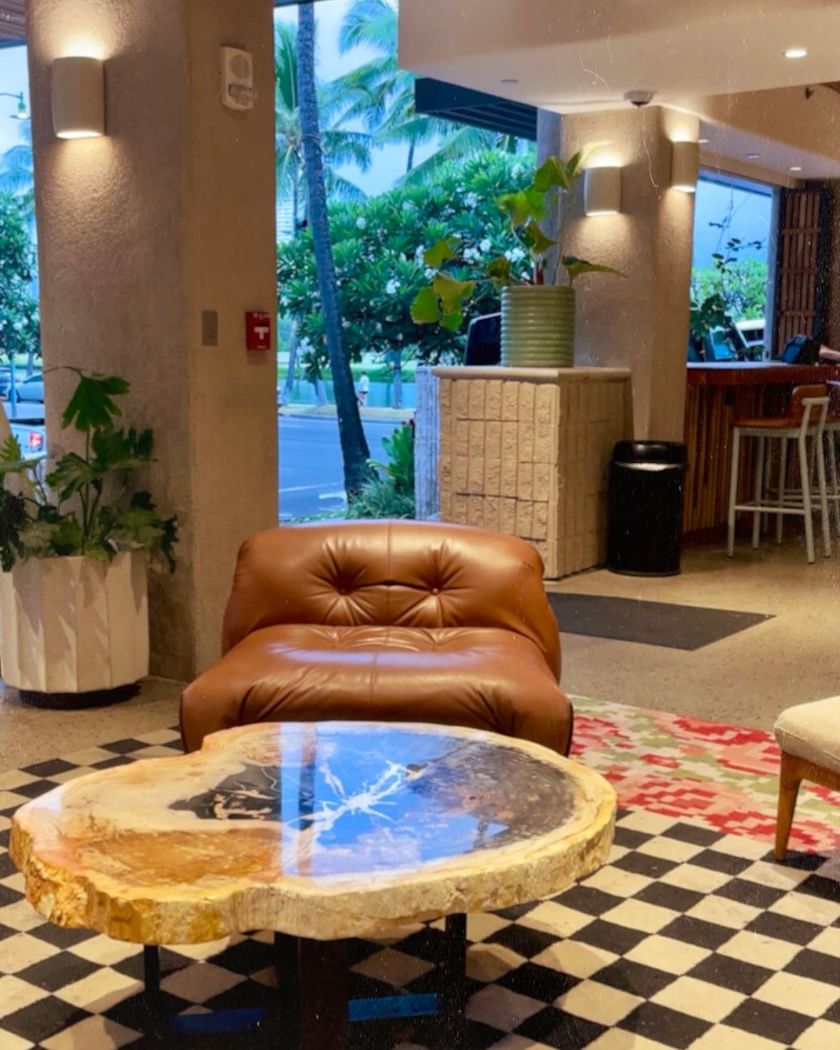 A hotel lobby with a brown chair and marble table