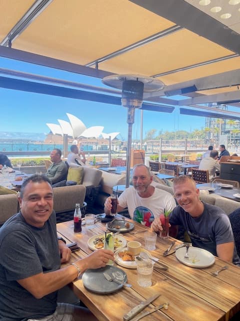 A group of people at an outdoor table posing for a photo together