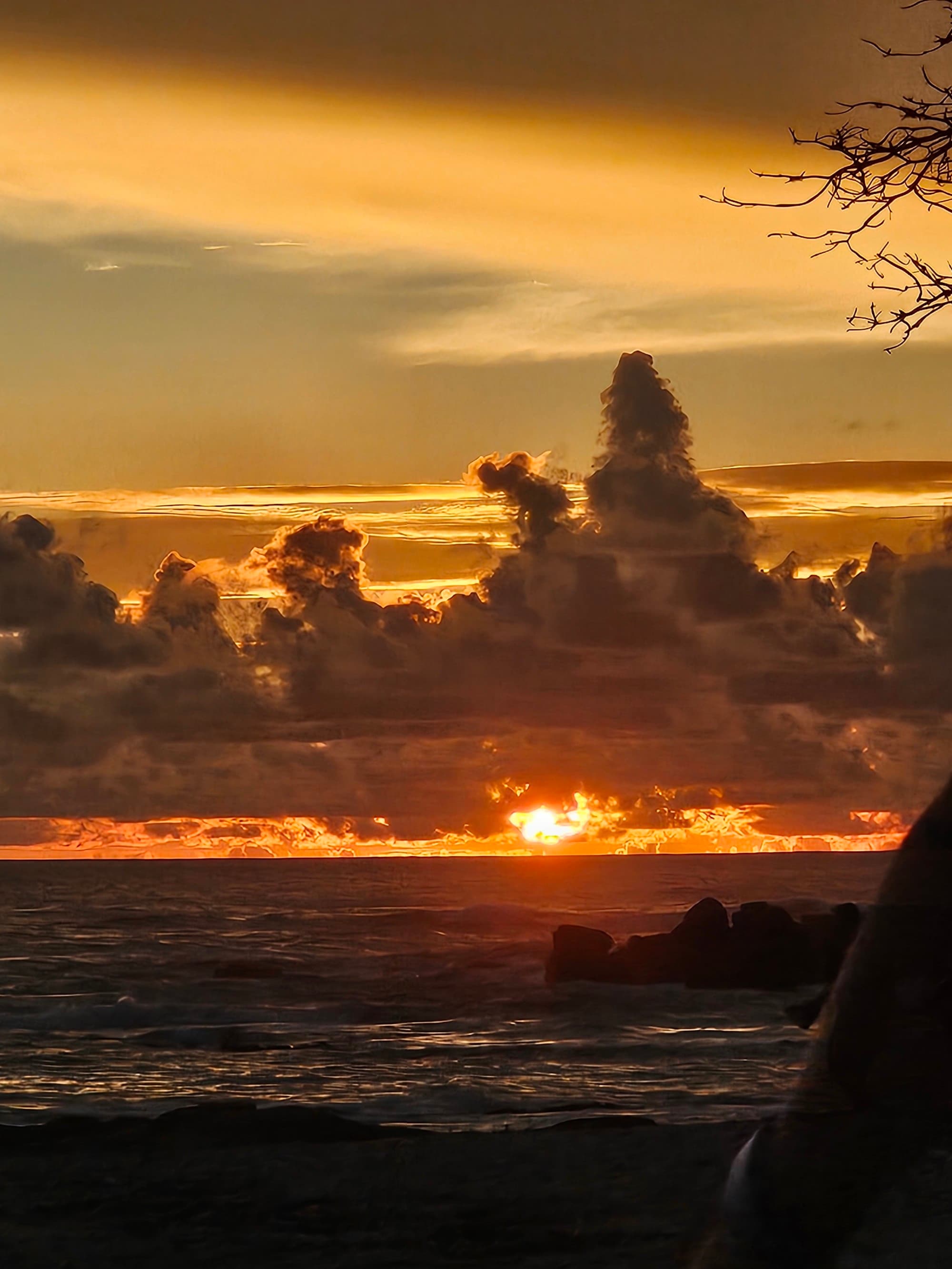 A sunset behind clouds above the water