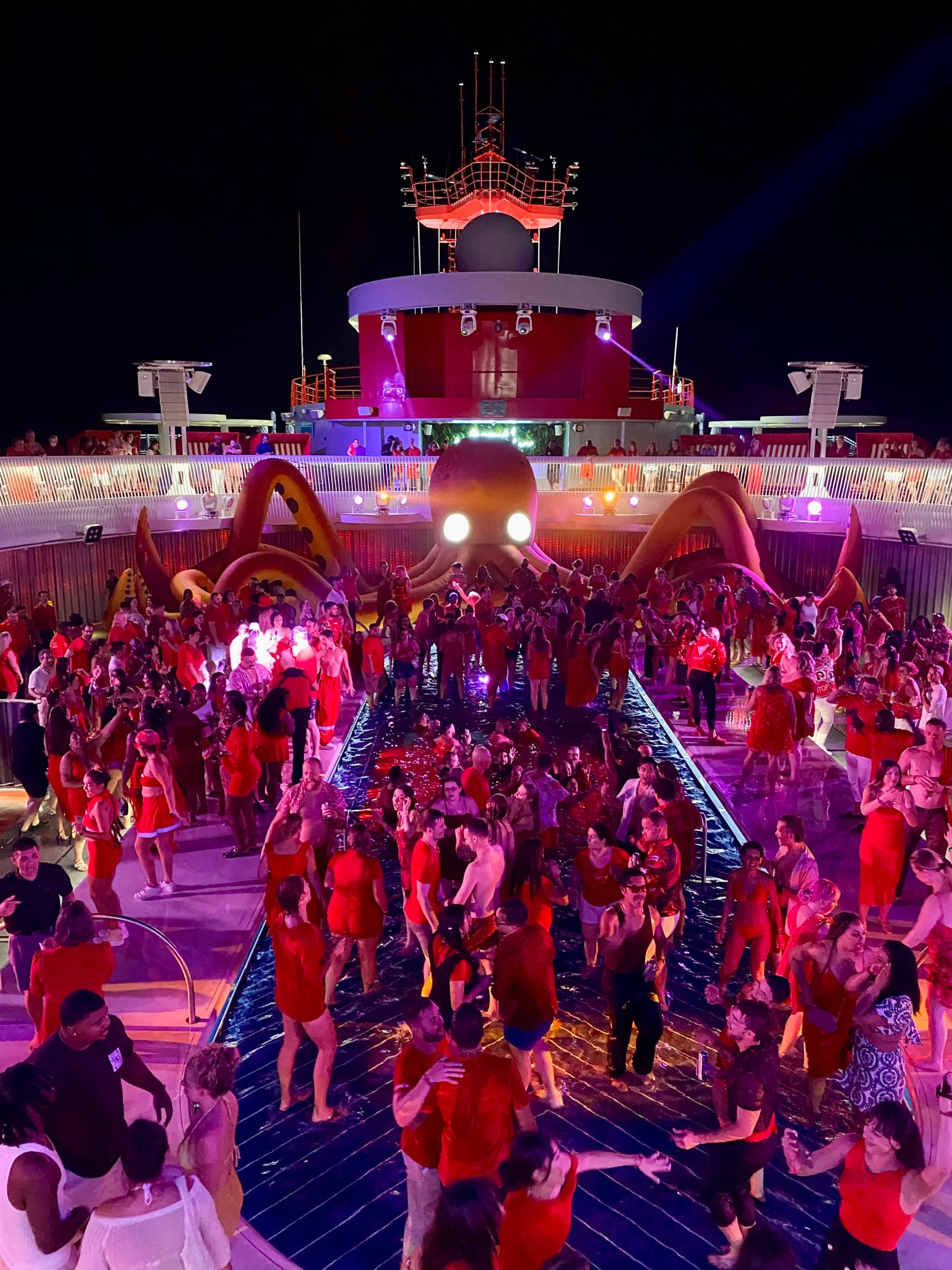 People dancing on a deck of a cruise ship during the nighttime