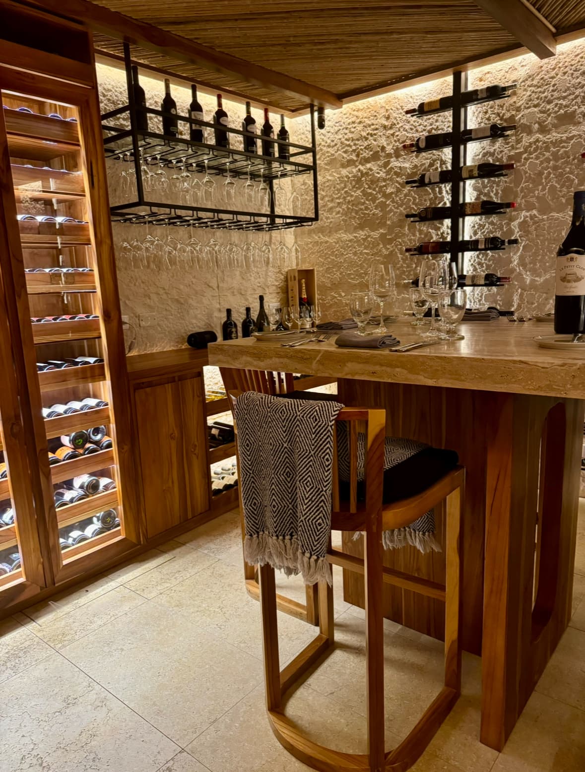 View of a private dinner room with rick furnishings and an extensive collection of wine.