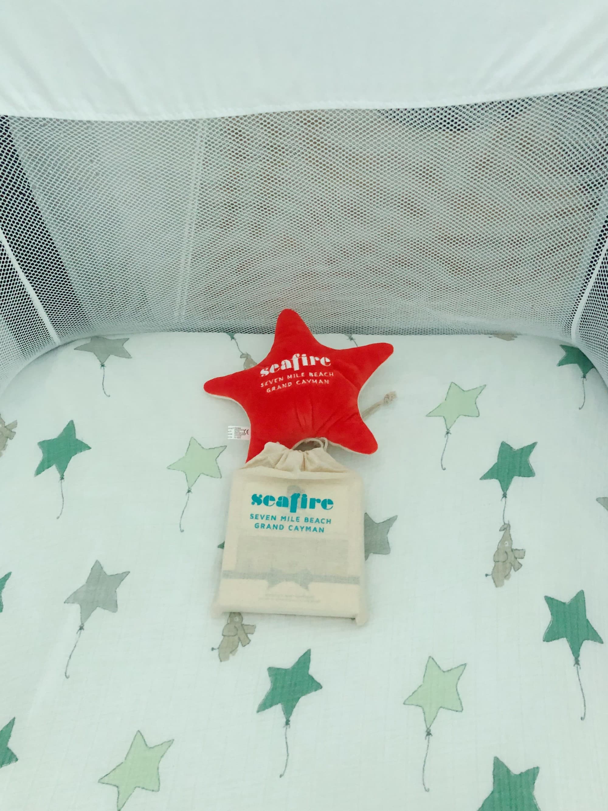 Crib with a stuffed seastar and star-printed sheets.