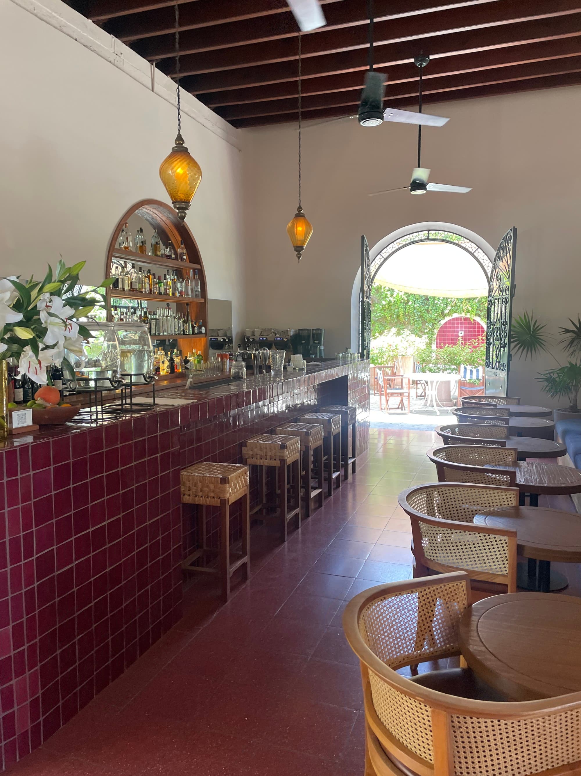 Lounge of the hotel with red tile bar and pendant lights.