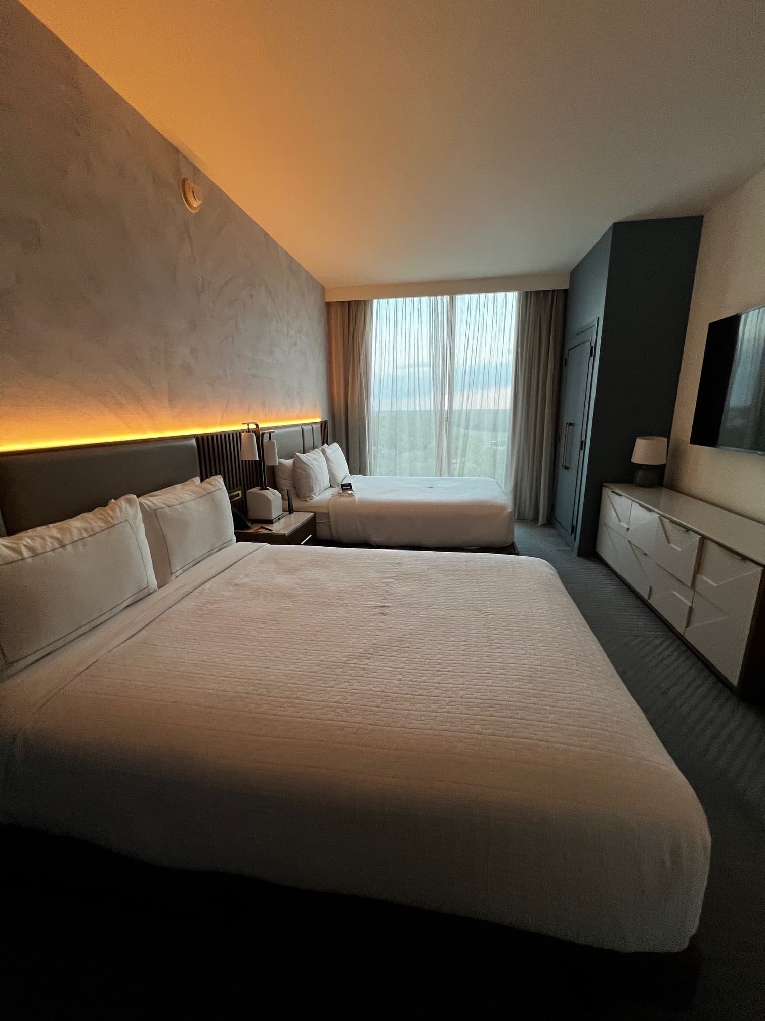 Hotel room with two queen-size beds with white linens.