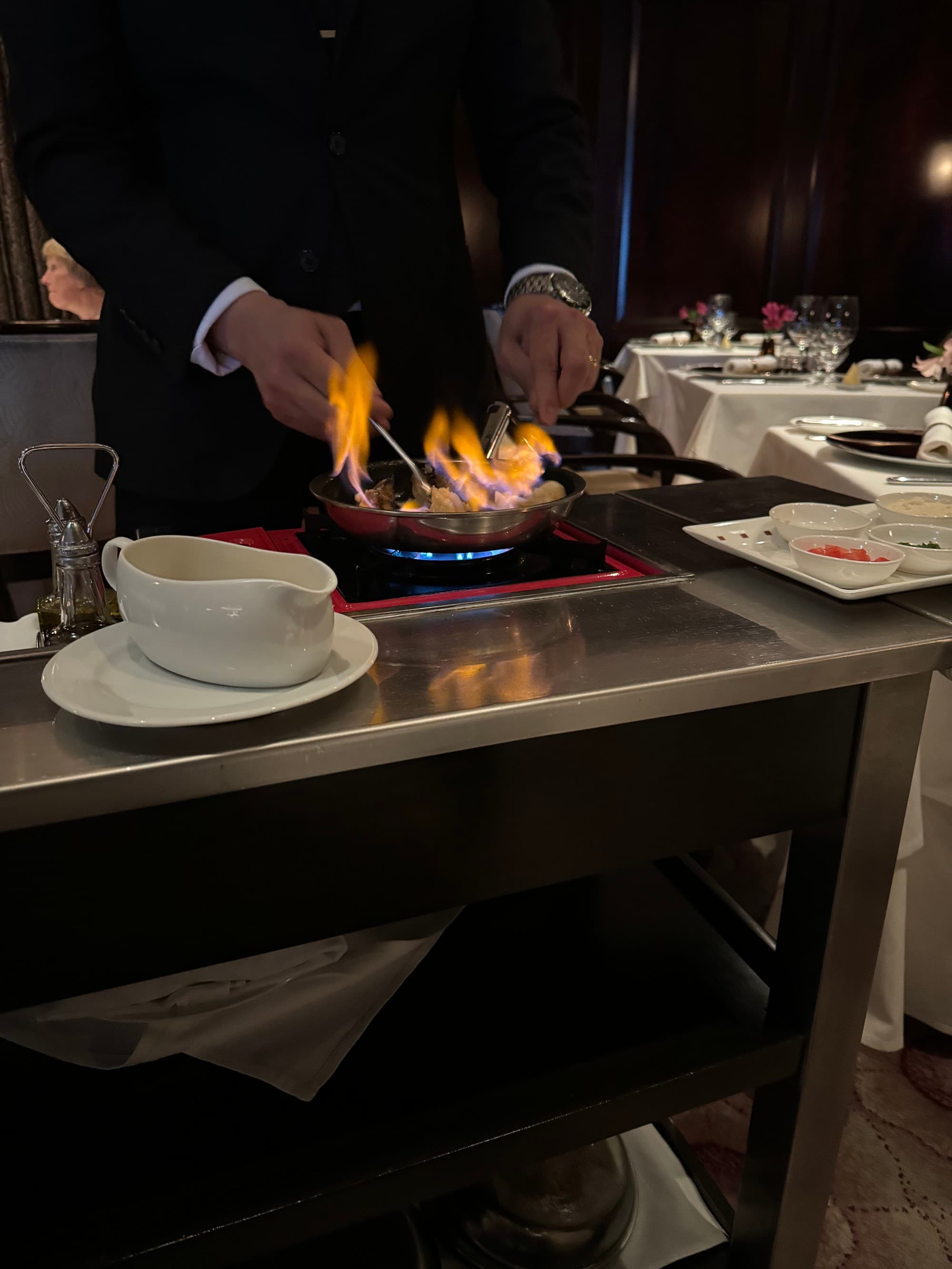 A view of a chef preparing food over an open flame.