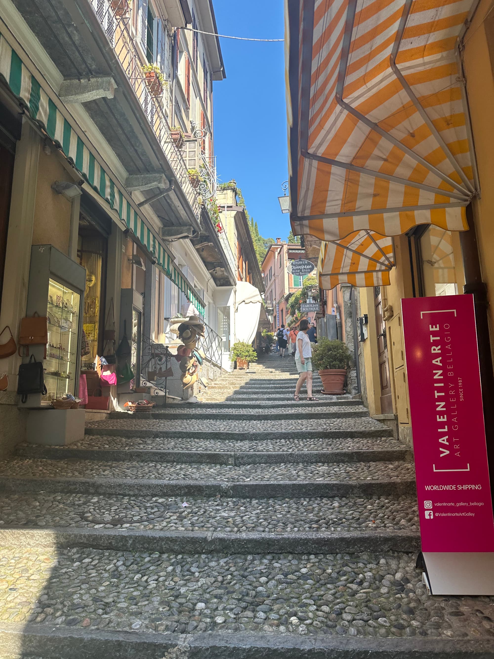 A street view looking down the steps with buildings and shops on either side. Bellagio - Georgia Goddard